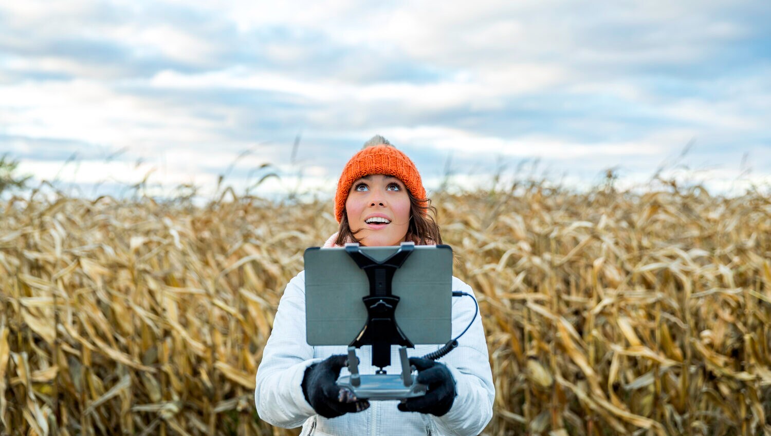 Eine Frau mit einer Fernsteuerung für eine Drohne in einem Feld