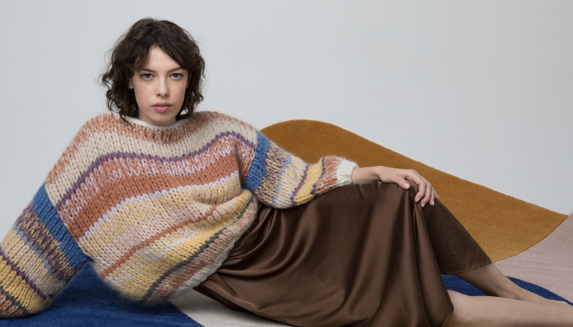 Eine Frau trägt einen Wollpullover mit Blockstreifen Eine Frau trägt einen Wollpullover mit Blockstreifen