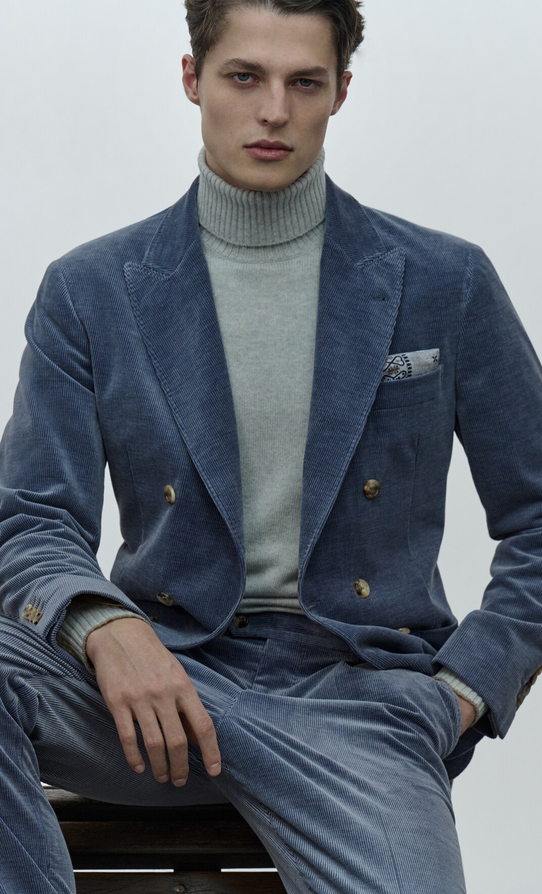 Eine Mann trägt einen Kaschmirpullover und Anzug Eine Mann trägt einen Kaschmirpullover und Anzug