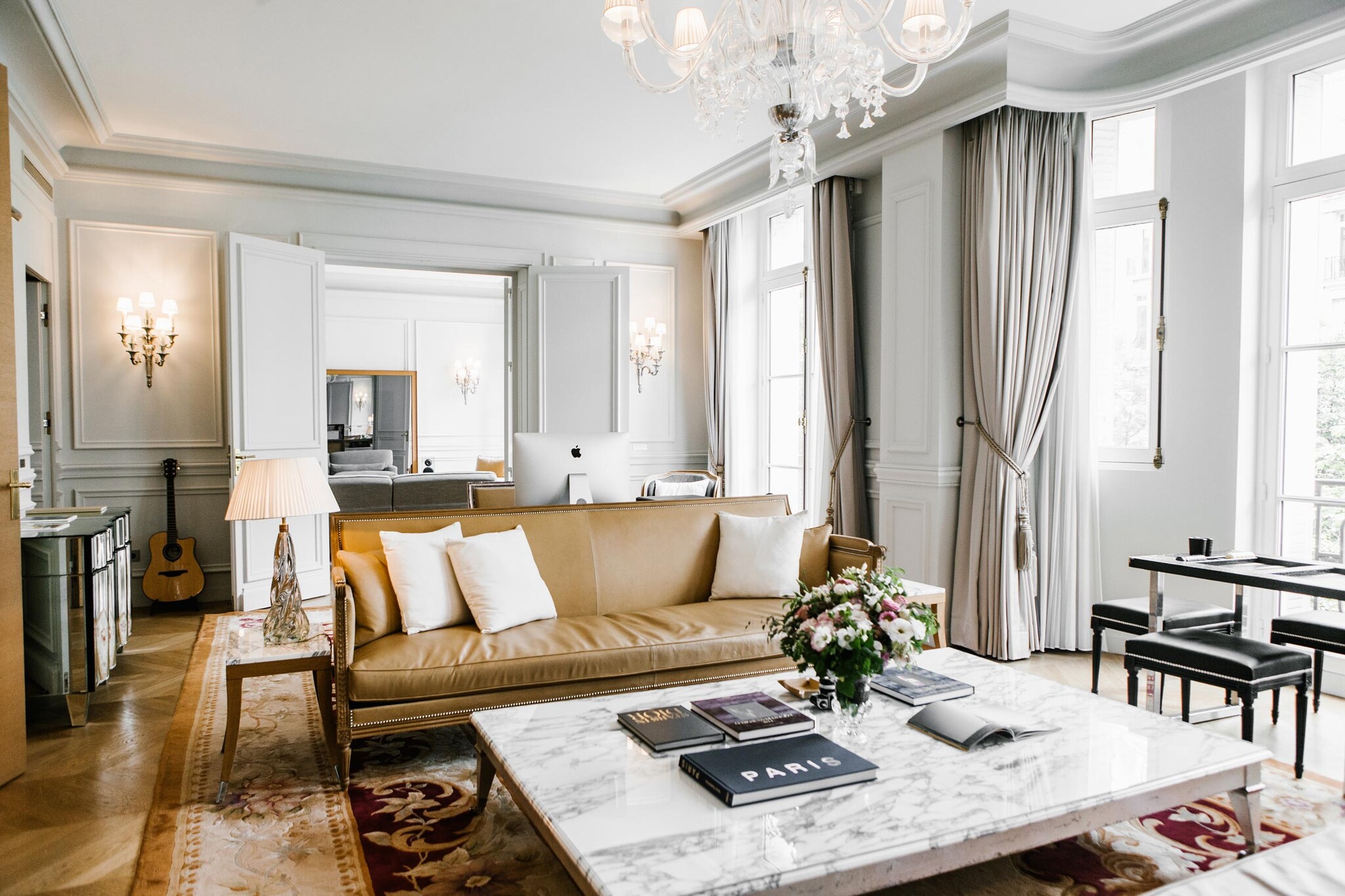 Ein Couchtisch mit einer Marmorplatte und ein braunes Ledersofa stehen In der Hotelsuite des Le Royal Monceau.