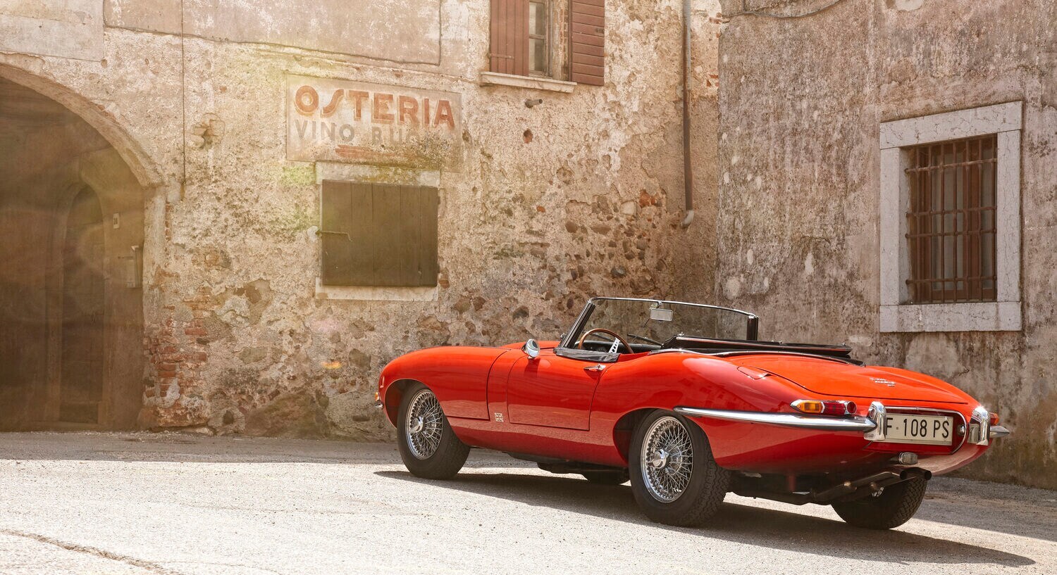 Ein Jaguar E-Type vor einer Osteria