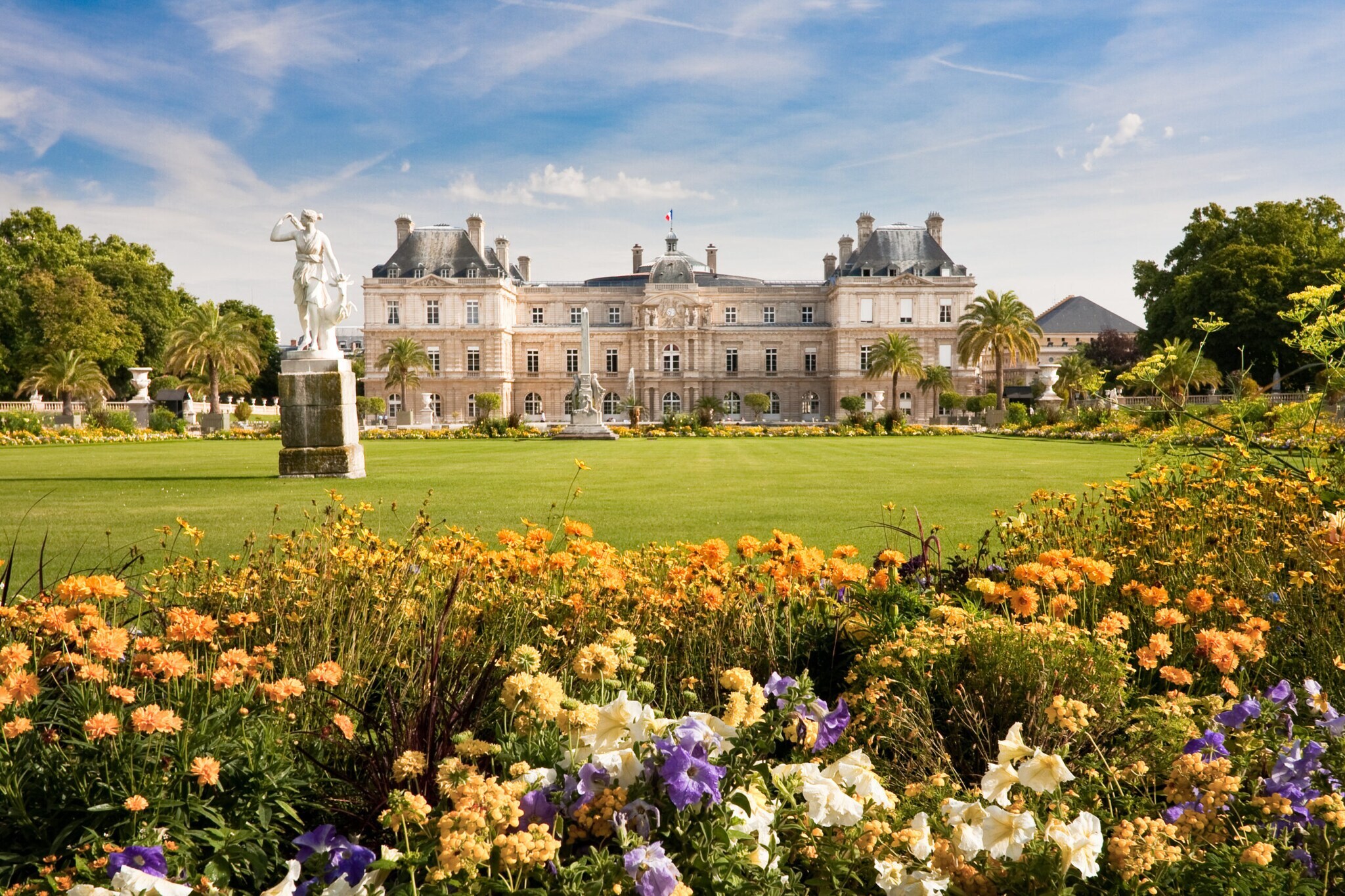 Bunte Blumen und eine Grasfläche vor dem Palais du Luxembourg.