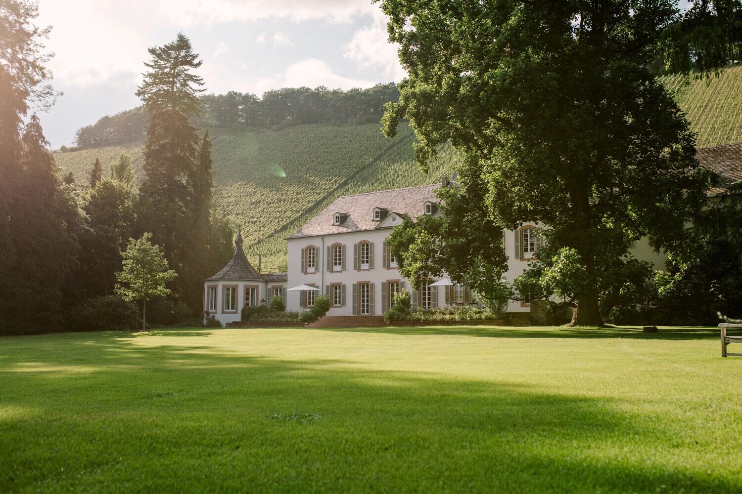Das historische Haupthaus auf Weingut Von Othegraven, umgeben von Rasenflächen und Bäumen
