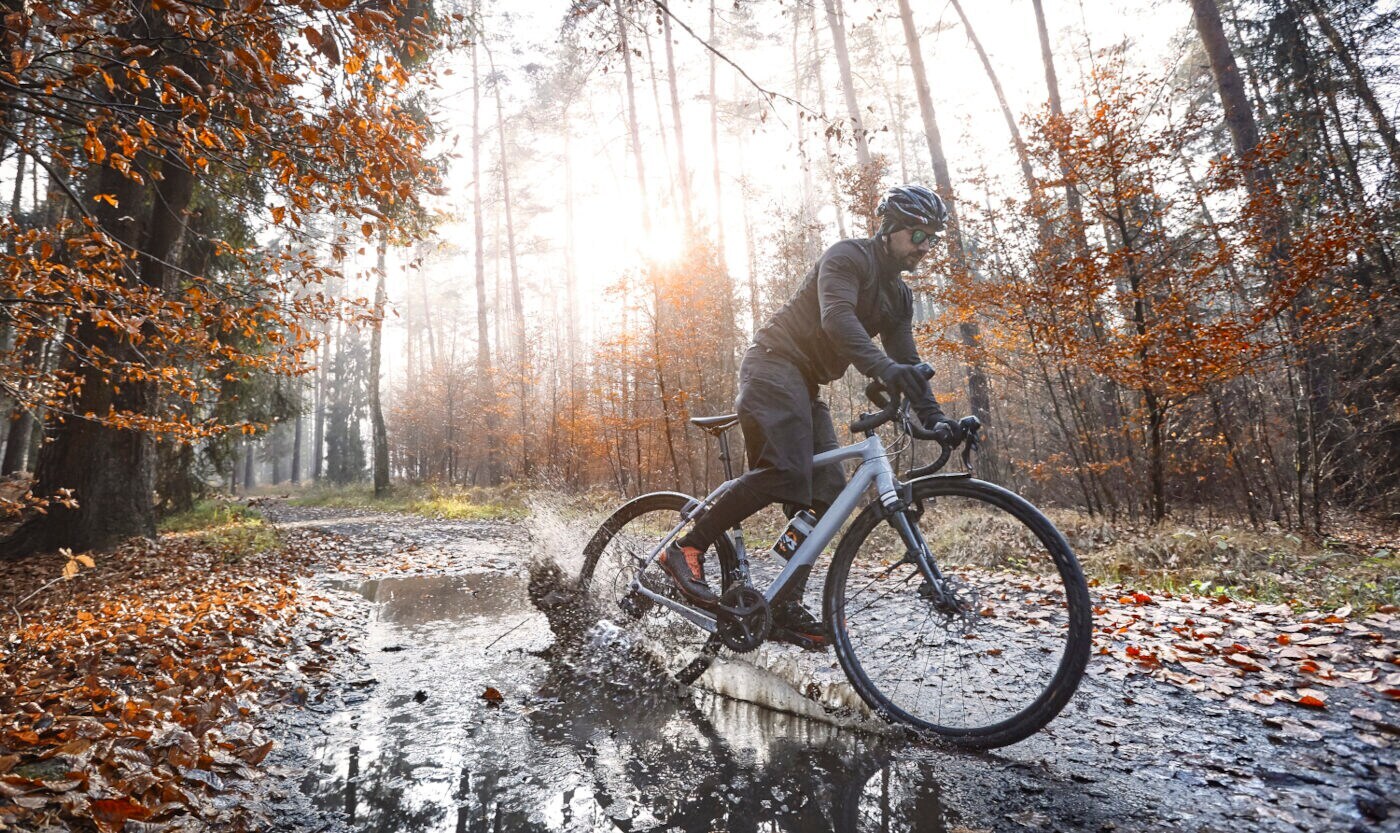 Ein Radfahrer fährt durch eine Pfütze.