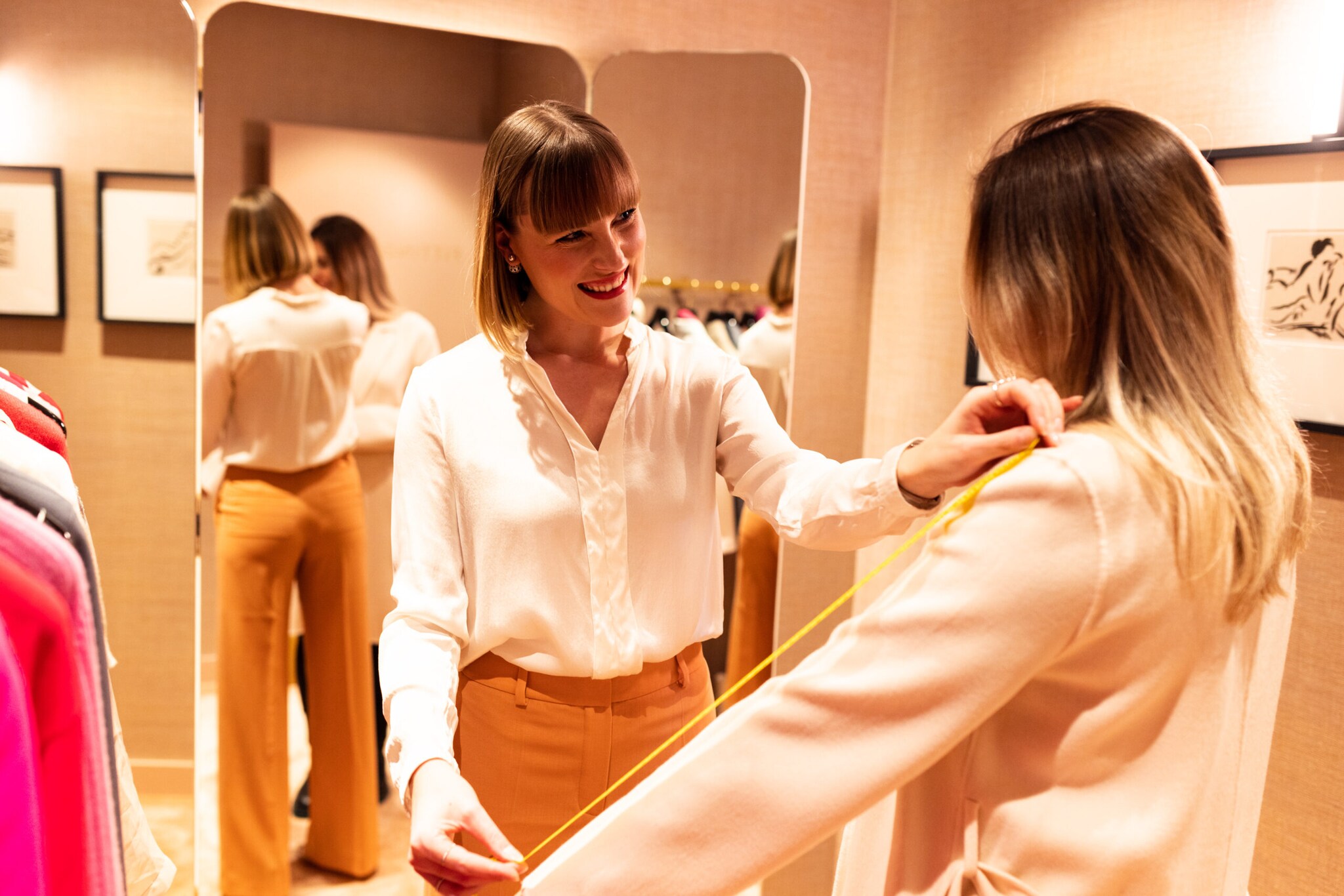 Eine Personal Shopperin nimmt bei ihrer Kundin Maß.