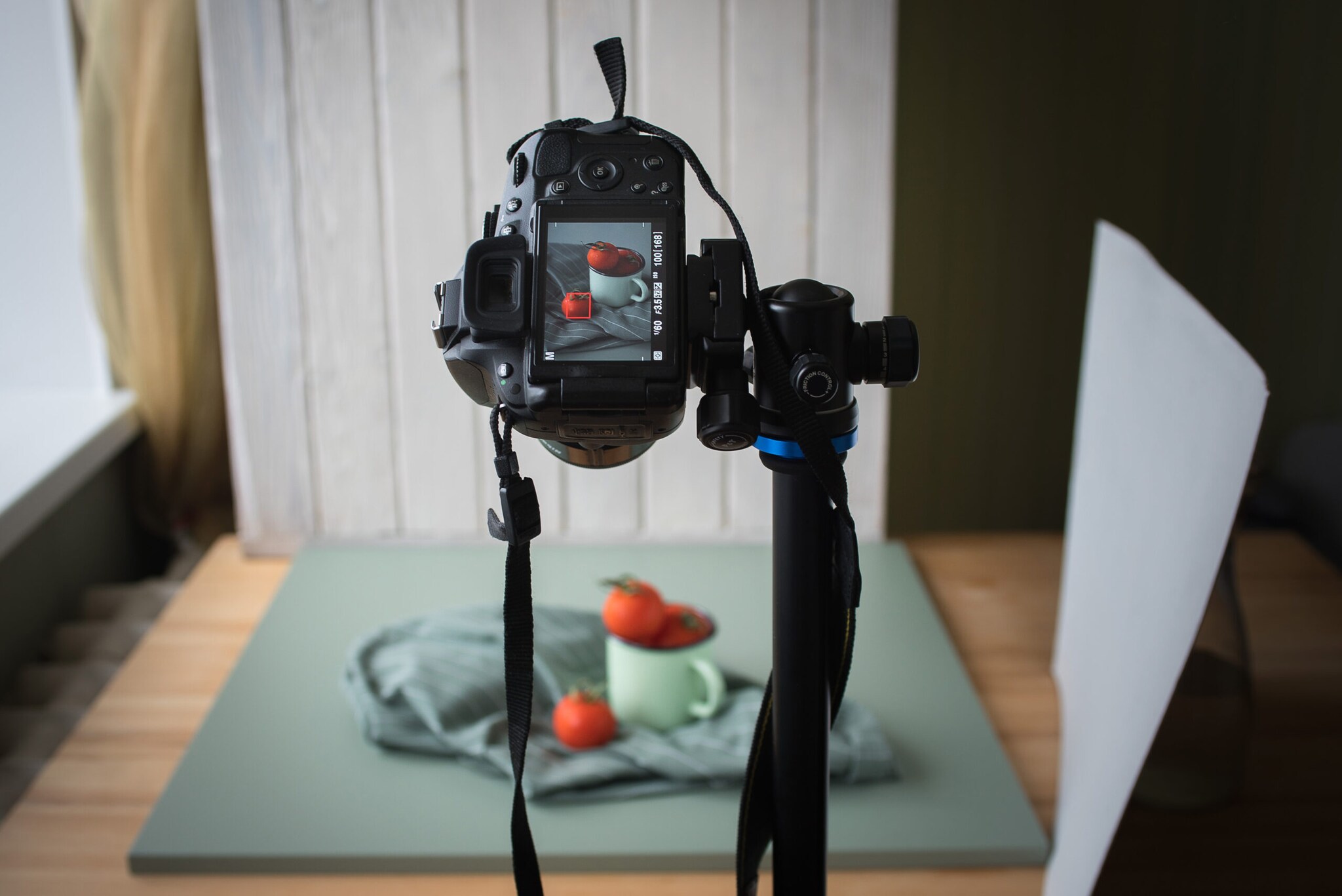 Eine Kamera auf einem Stativ vor einem kleinen Studio