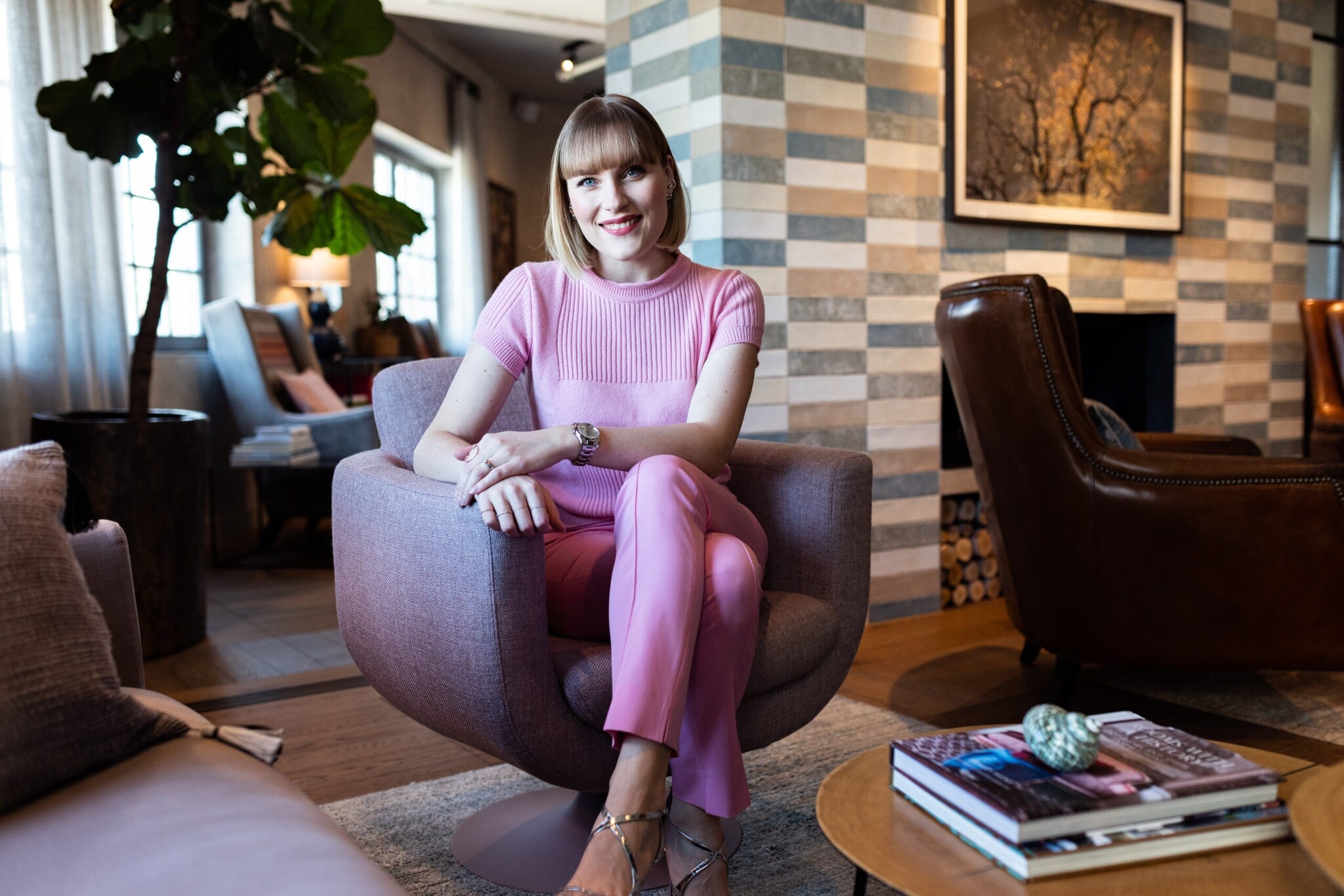 Eine Frau in rosa Outfit sitzt in einem Sessel Eine Frau in rosa Outfit sitzt in einem Sessel