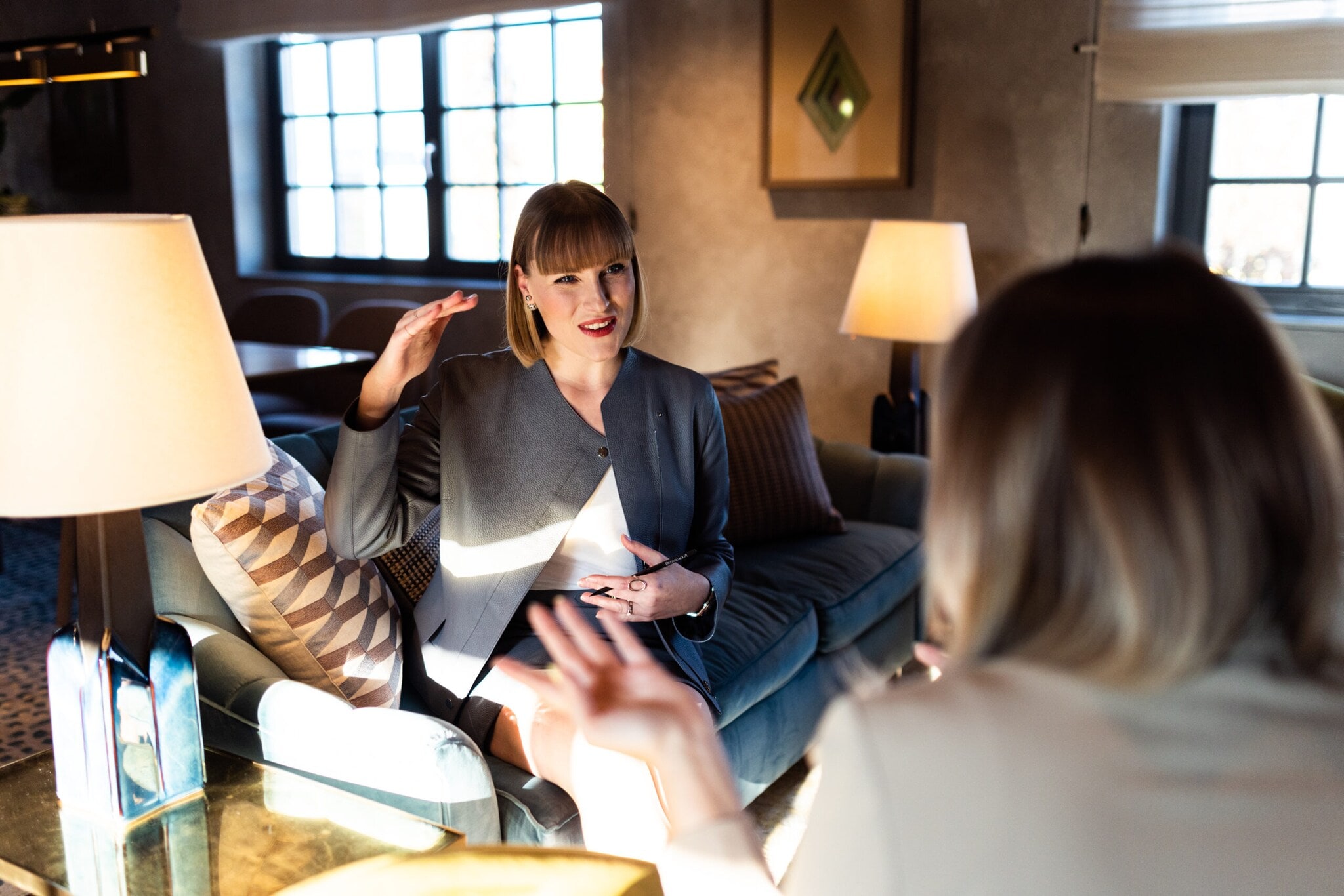 Eine Personal Shopperin sitzt ihrer Kundin gegenüber und ist im Gespräch vertieft. Eine Personal Shopperin sitzt ihrer Kundin gegenüber und ist im Gespräch vertieft.
