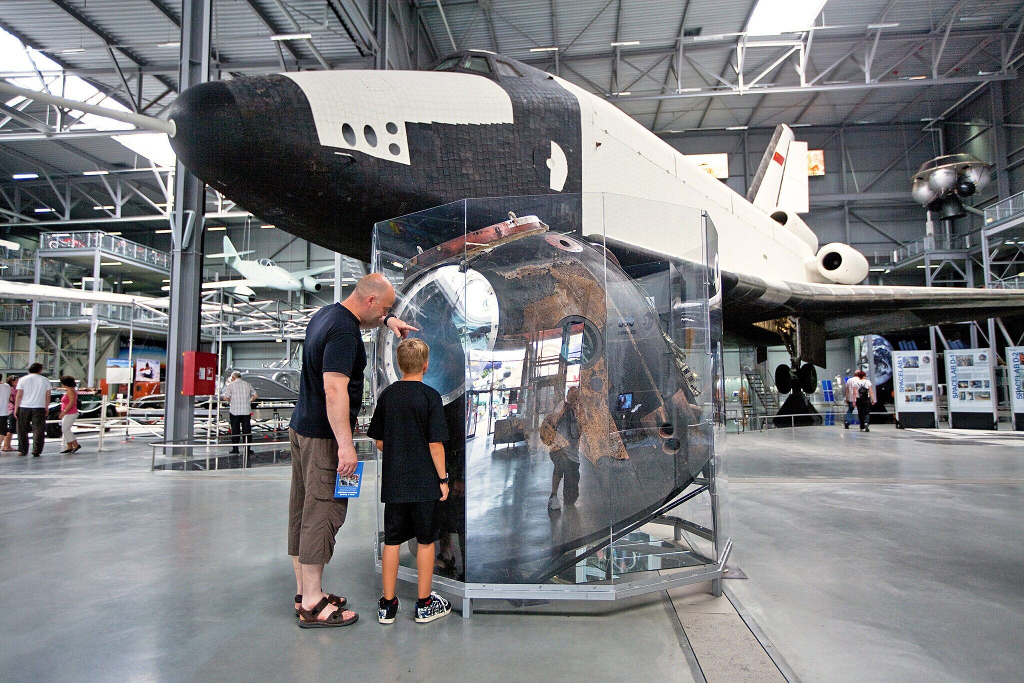 Zwei Menschen sehen sich das original Spaceshuttle Buran im Technik Museum Speyer an.