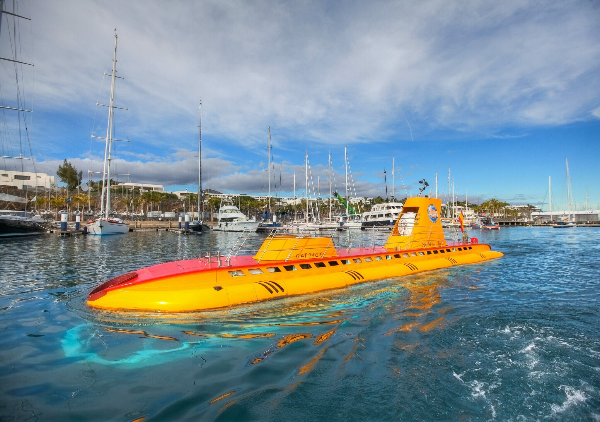 Orange-gelbes U-Boot des Anbieters Submarine Safaris an der Wasseroberfläche.
