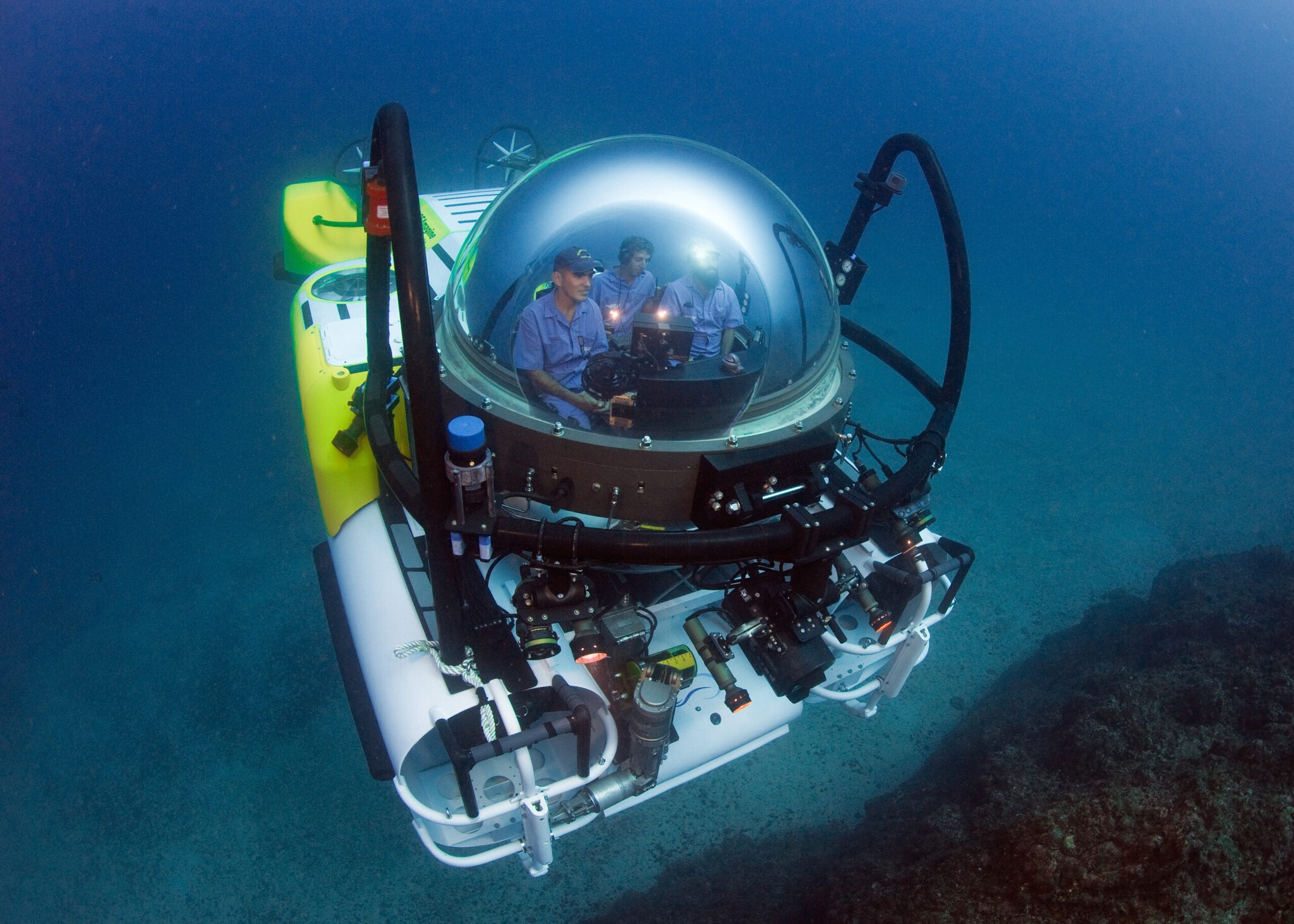 Das Forschungstauchboot DeepSee mit Glaskuppel, in der mehrere Personen sitzen.