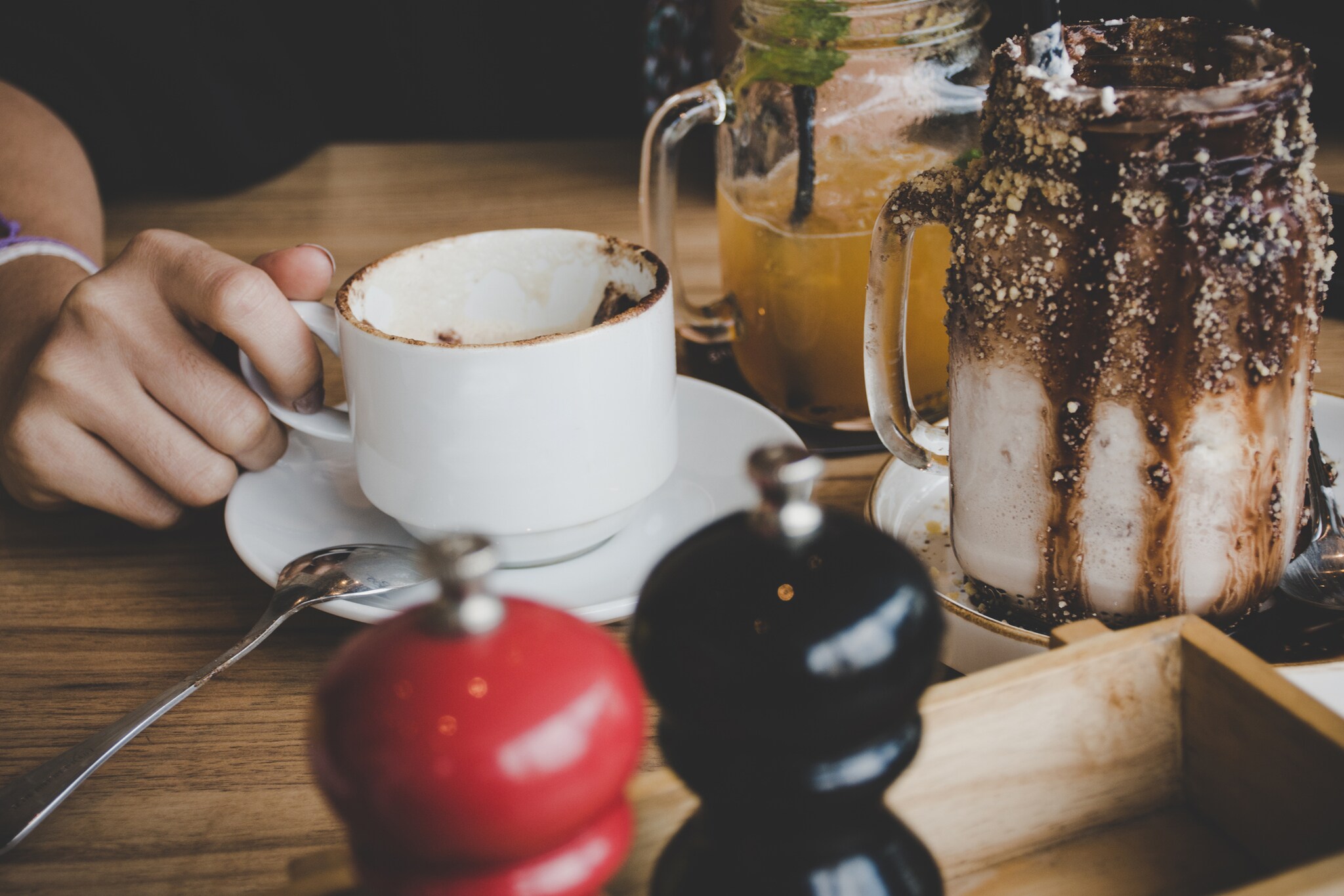 Eine Tasse neben einem Trinkbecher mit Schokoladenrand.