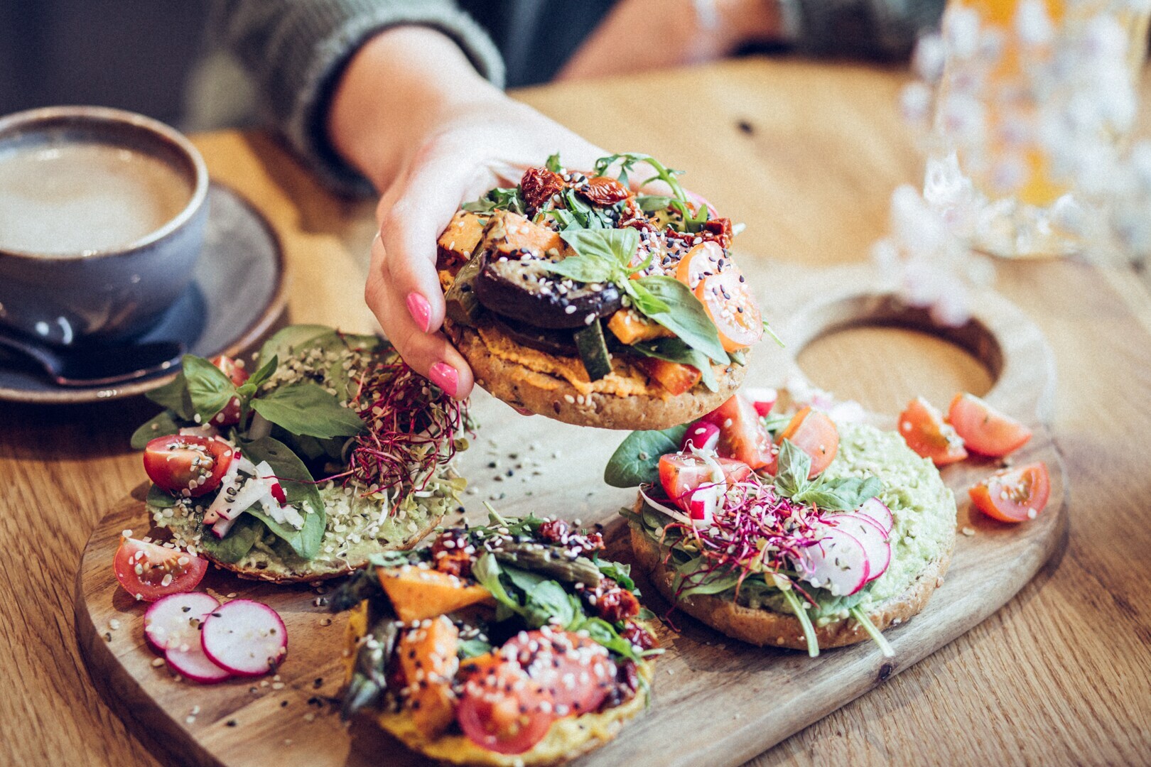 Mehrere belegte Brote mit frischem Gemüse auf einem Holzbrett.