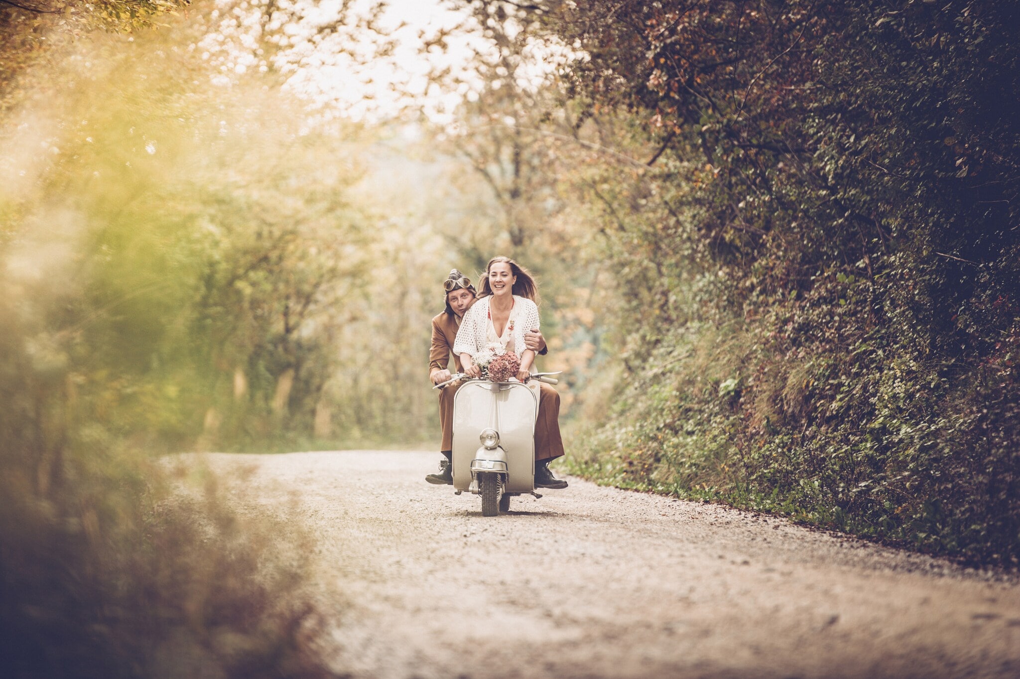 Ein junges Pärchen auf einer alten Vespa Ein junges Pärchen auf einer alten Vespa