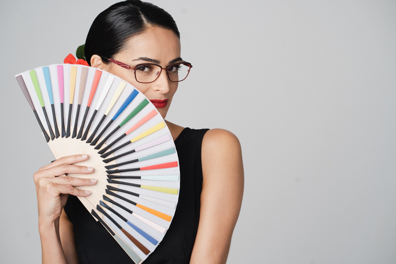 Eine Frau mit einem Fächer aus bunten Brillenbügeln