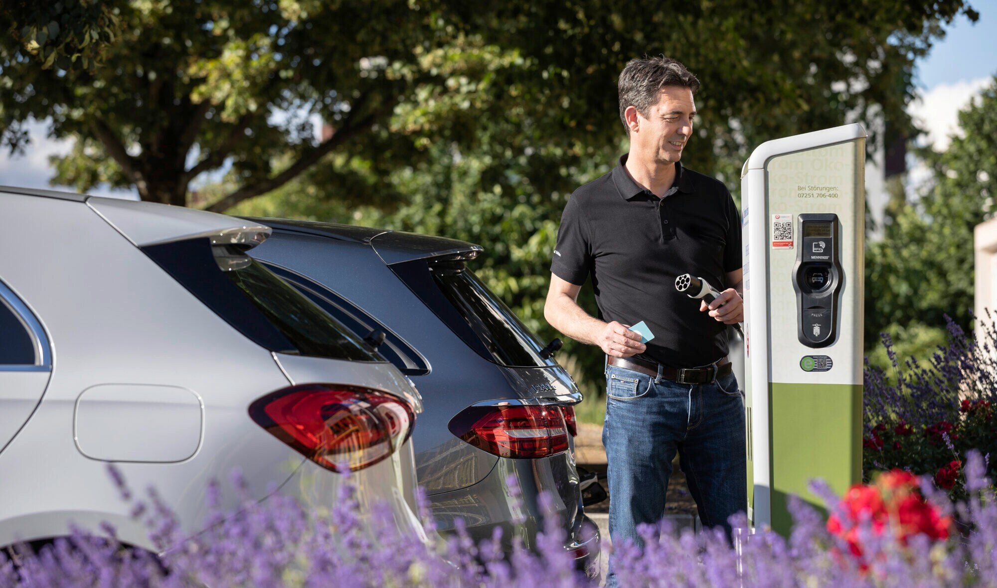 Ein Mann steht an einer Ladesäule