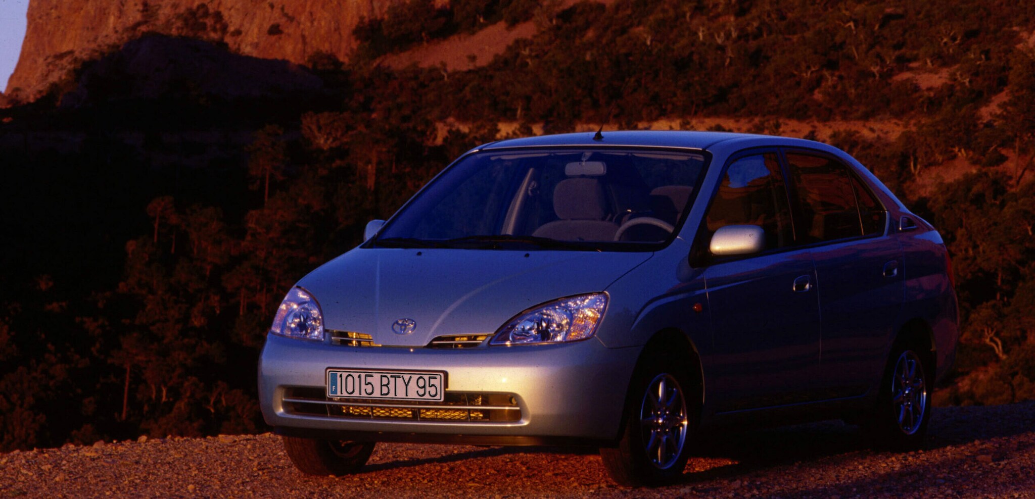 Ein silbernes Auto vor roten Felsen