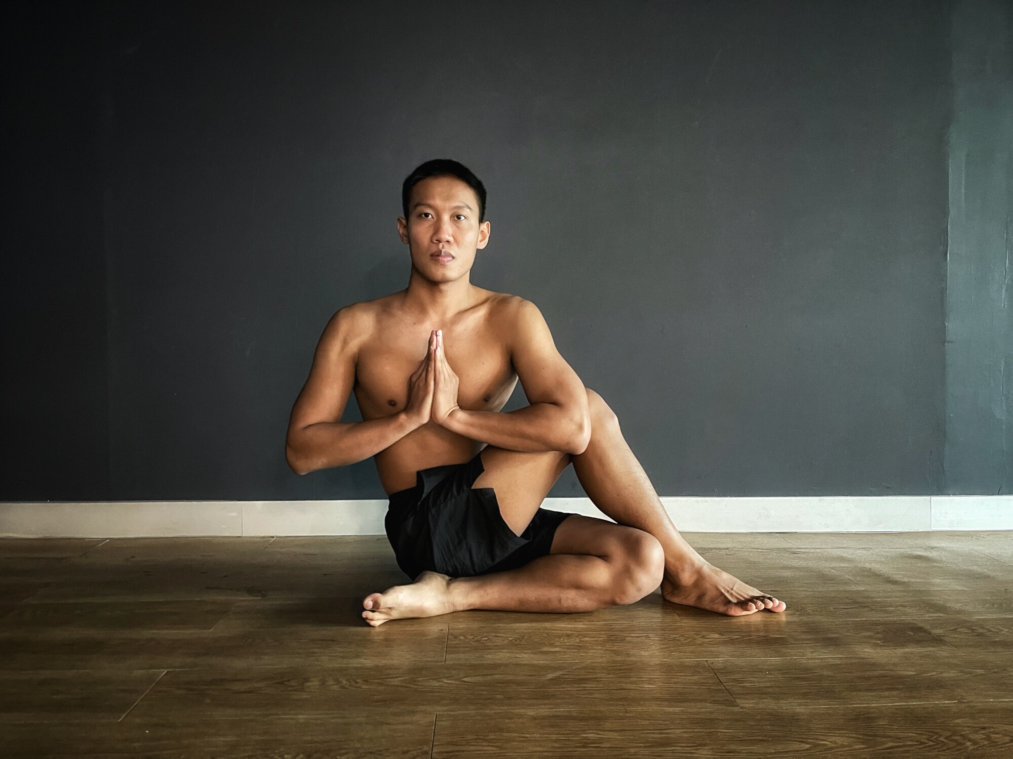 Mann macht Yoga, sitzt im halben Drehsitz Mann macht Yoga, sitzt im halben Drehsitz