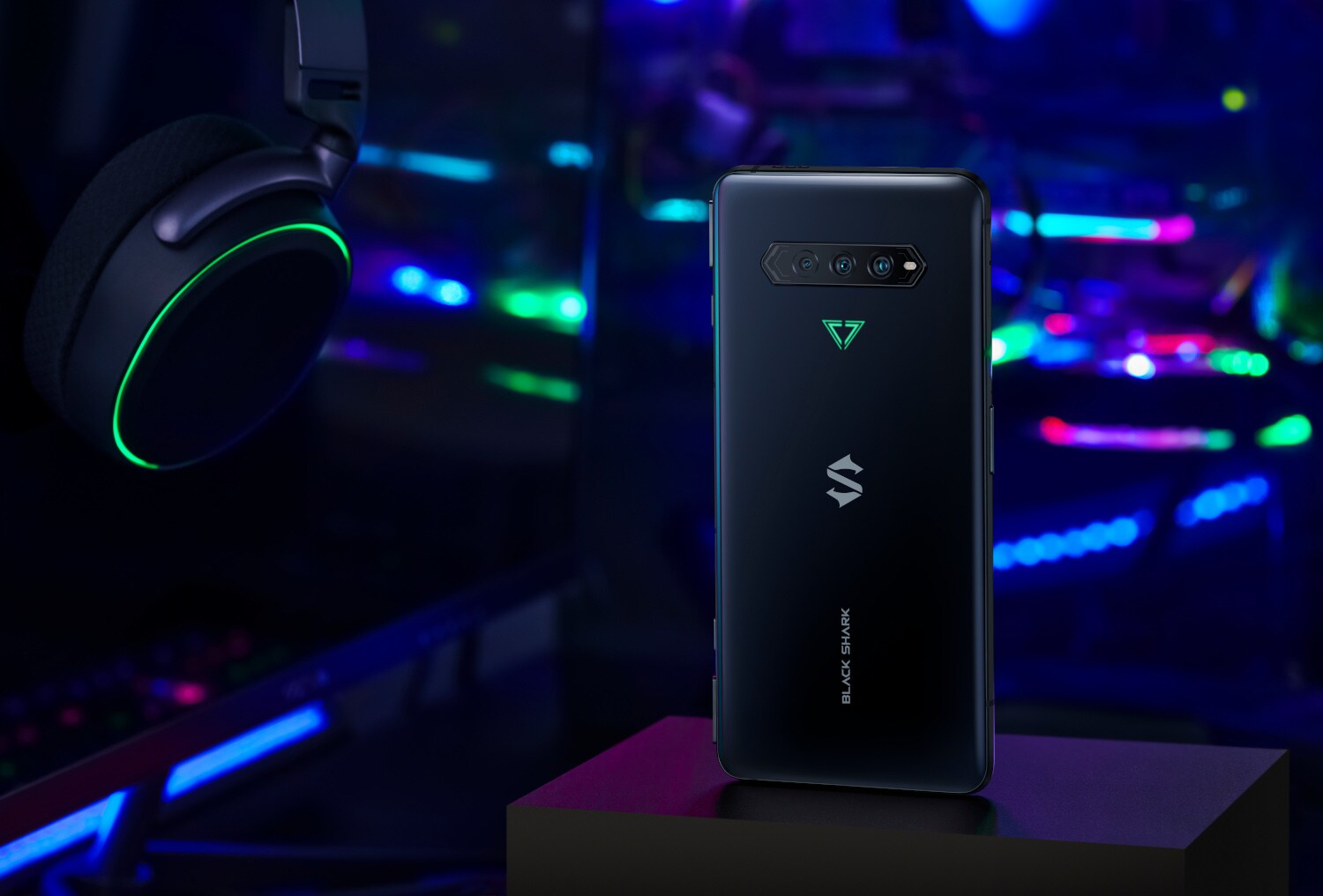 Die Rückseite eines Handys zwischen bunten LED-Lichtern und einem Kopfhörer