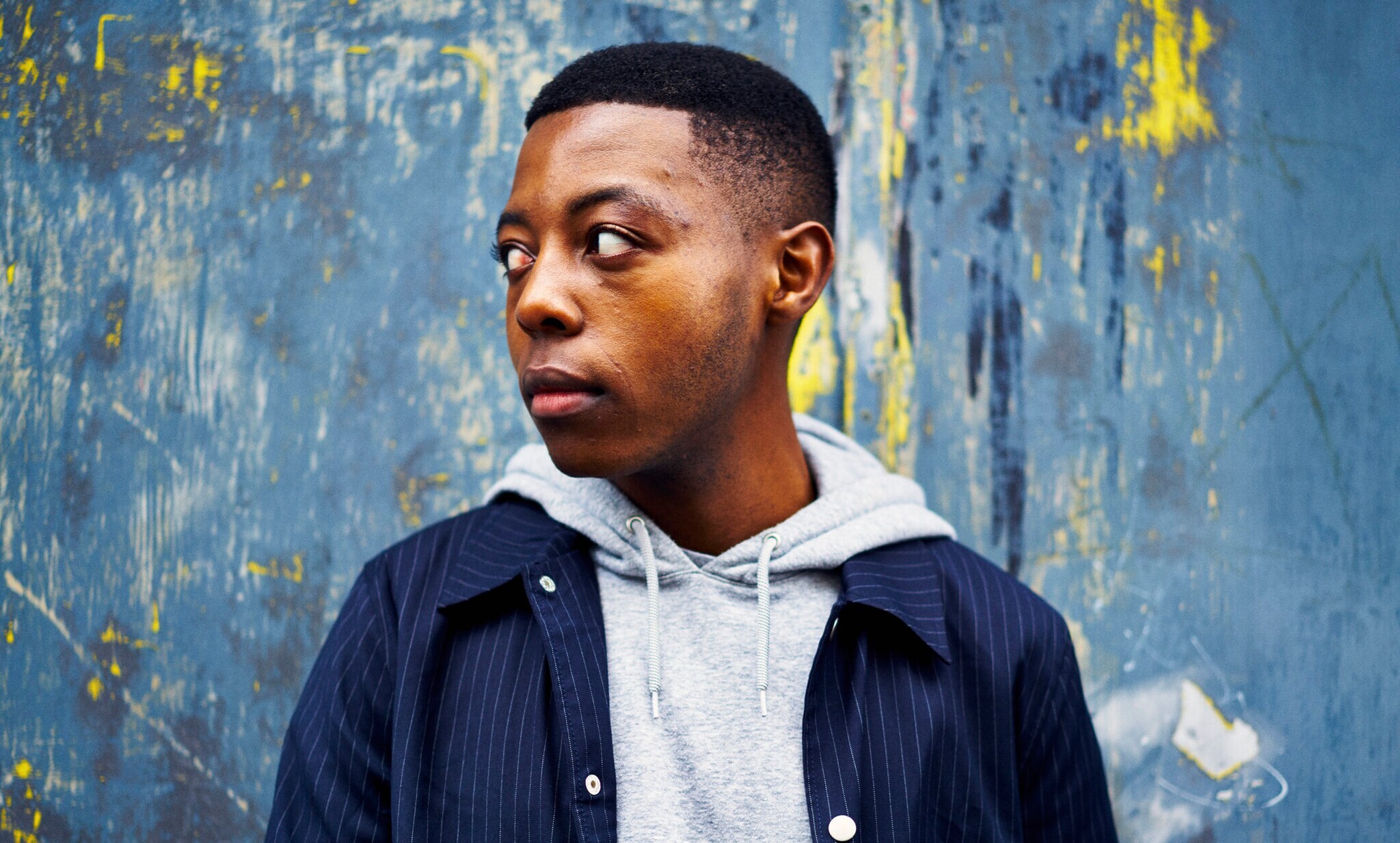 Close-Up eines jungen Mannes in Hoodie und Hemdjacke.