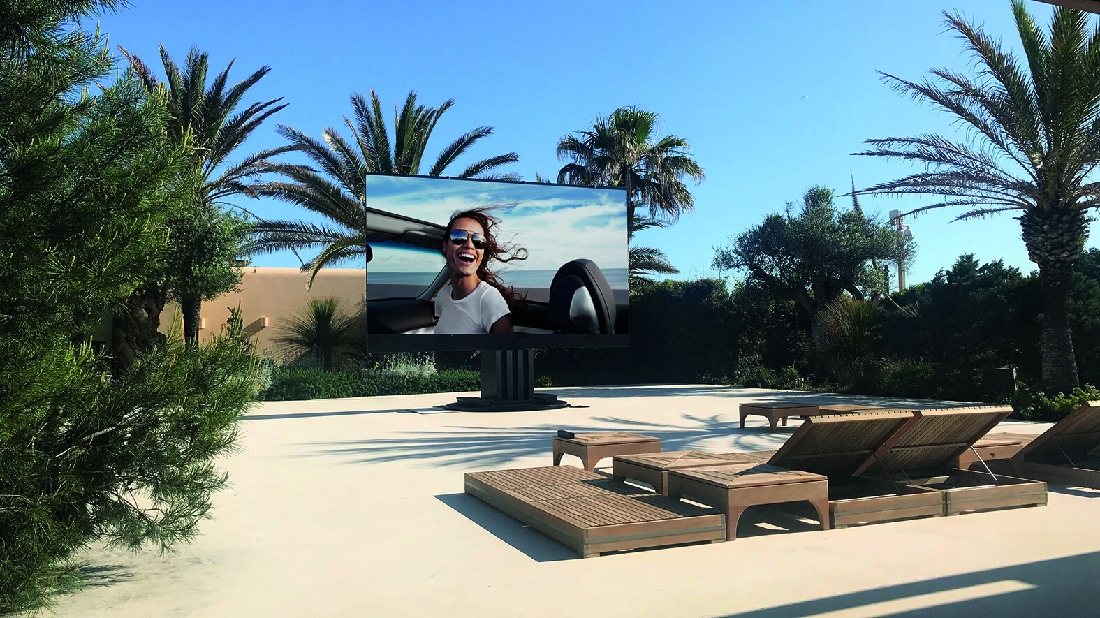 Der Fernseher C SEED 201 in einem großzügigen Terrassenbereich und von Palmen umgeben. Der Fernseher C SEED 201 in einem großzügigen Terrassenbereich und von Palmen umgeben.
