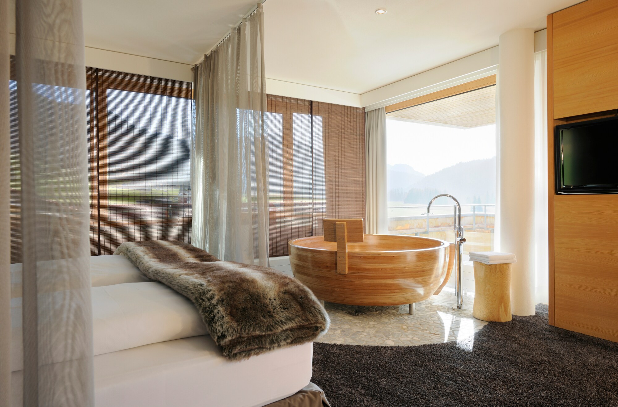 Eine moderne Hotelsuite mit runder Badewanne aus Holz