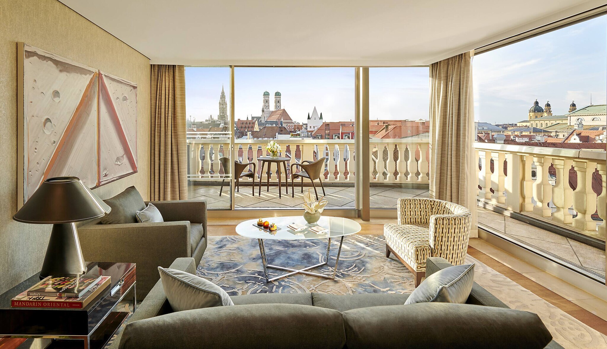 Eine luxuriöse Hotelsuite mit Balkon und Panoramablick auf München Eine luxuriöse Hotelsuite mit Balkon und Panoramablick auf München