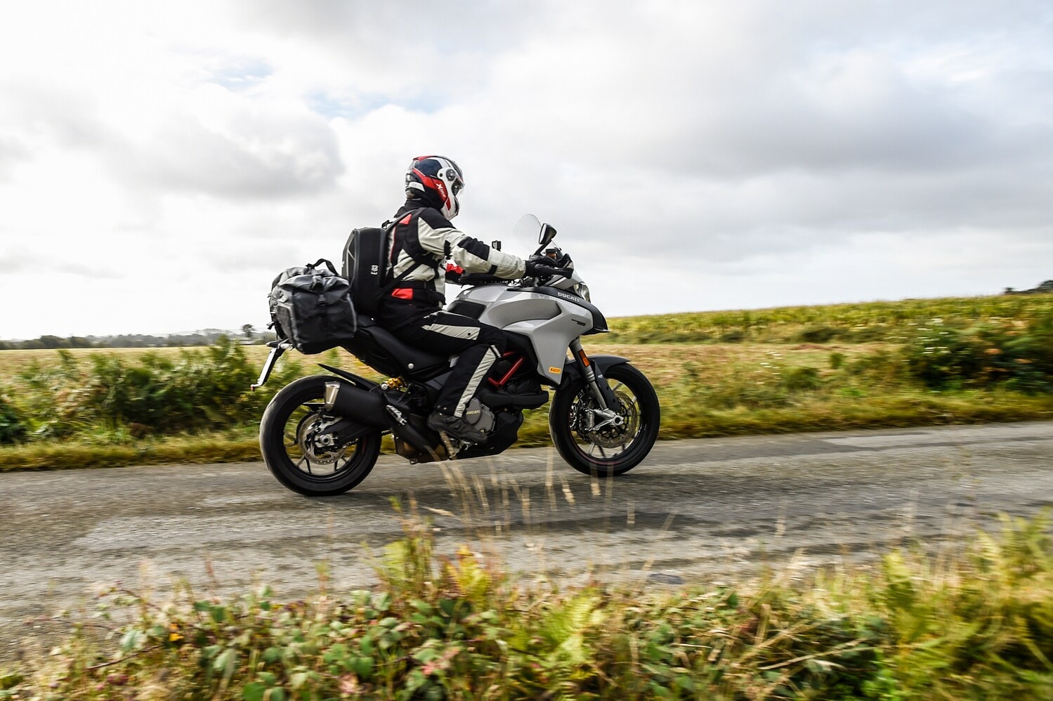 Ein Motorradfahrer fährt von links nach rechts auf einer Ducati Multistrada 950 (V2) durchs Bild. Ein Motorradfahrer fährt von links nach rechts auf einer Ducati Multistrada 950 (V2) durchs Bild.