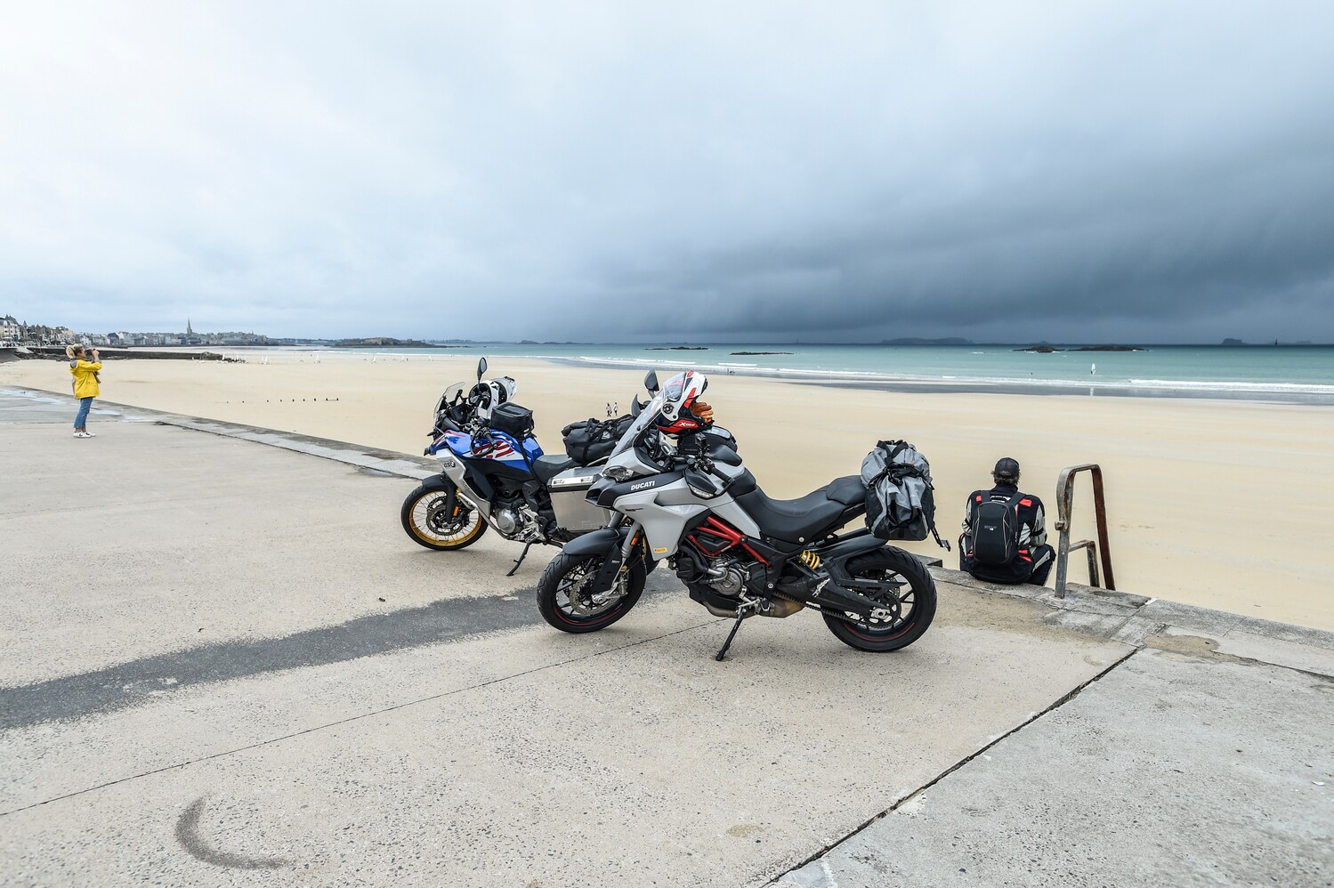 Zwei Motorräder auf einer Straße vor einem Strand