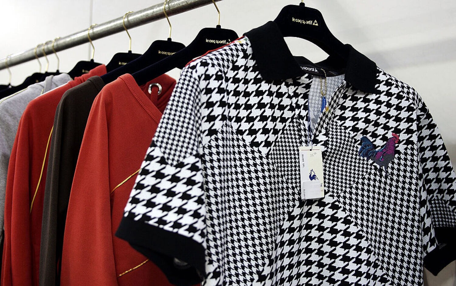 Mehrere Kleidungsstücke für Männer hängen auf Bügeln nebeneinander.