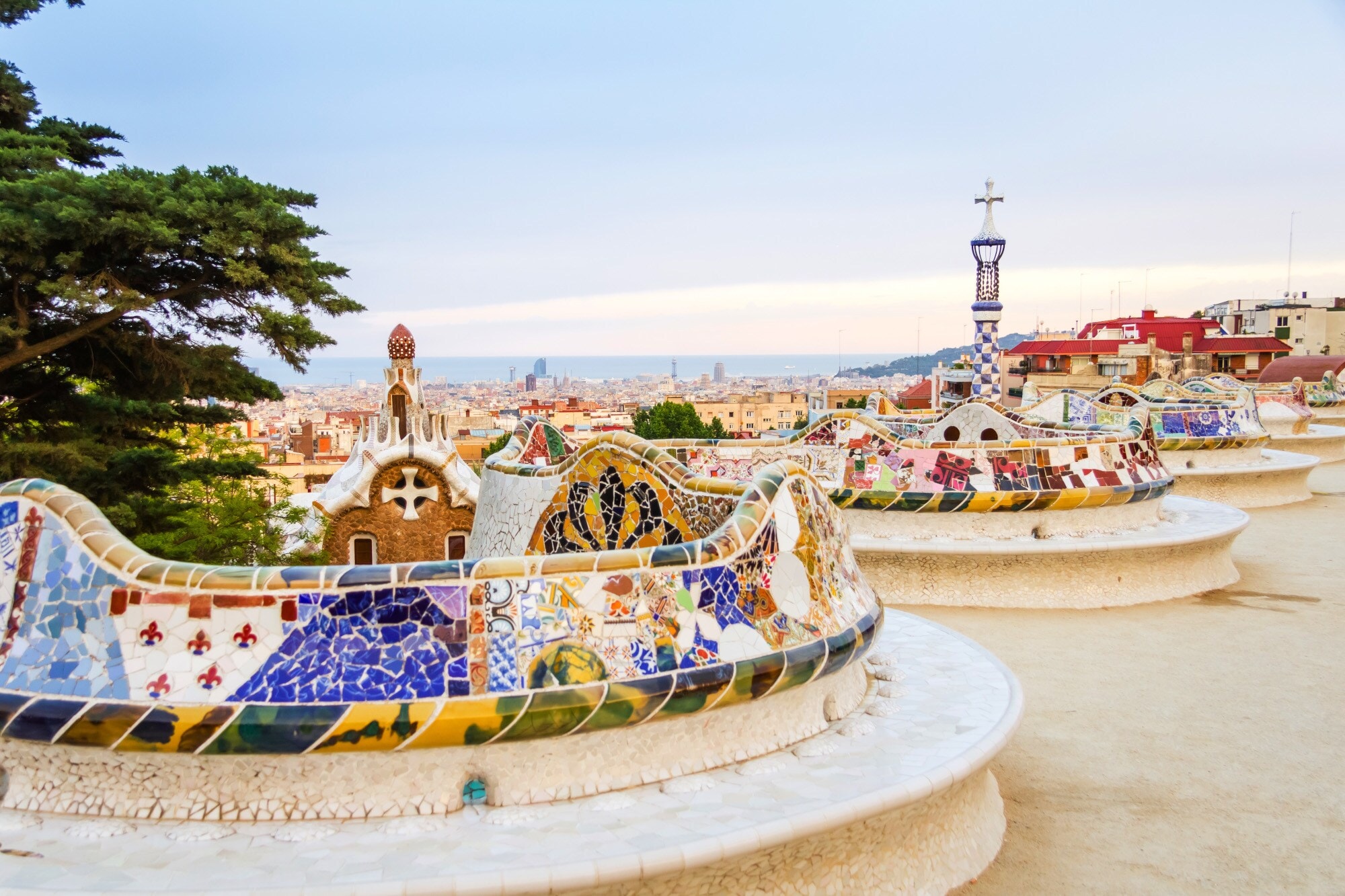 Geschwungene, mosaikbesetzte Bank im Park Güell mit Blick über Barcelona Geschwungene, mosaikbesetzte Bank im Park Güell mit Blick über Barcelona