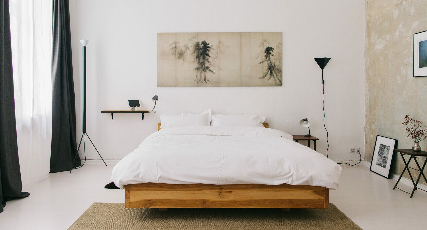 Ein weißer Raum mit einem Bett in der Mitte im Japandi-Stil