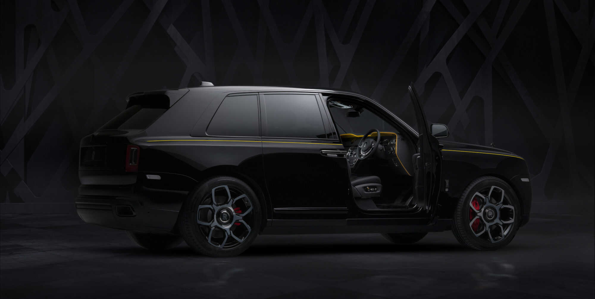 Ein schwarzer Rolls-Royce Cullinan im Studio mit geöffneter Fahrertür