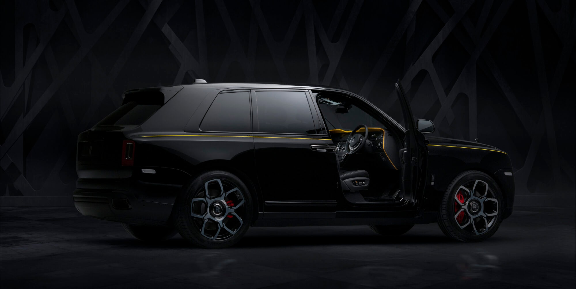 Ein schwarzer Rolls-Royce Cullinan im Studio mit geöffneter Fahrertür Ein schwarzer Rolls-Royce Cullinan im Studio mit geöffneter Fahrertür