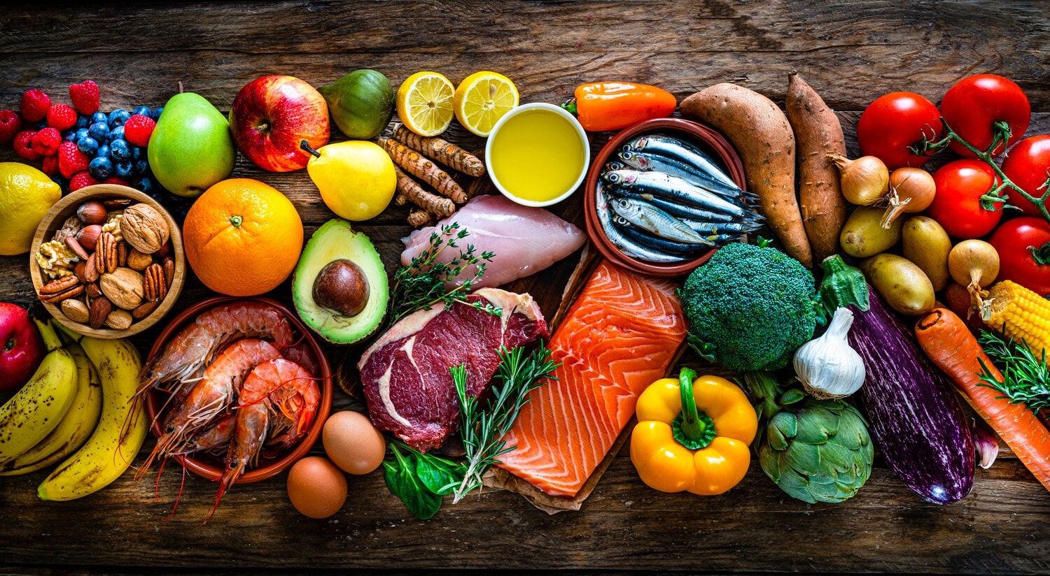 Gesunde, unverarbeitete Lebensmittel der Paleo-Ernährung nebeneinander aufgereiht. Gesunde, unverarbeitete Lebensmittel der Paleo-Ernährung nebeneinander aufgereiht.