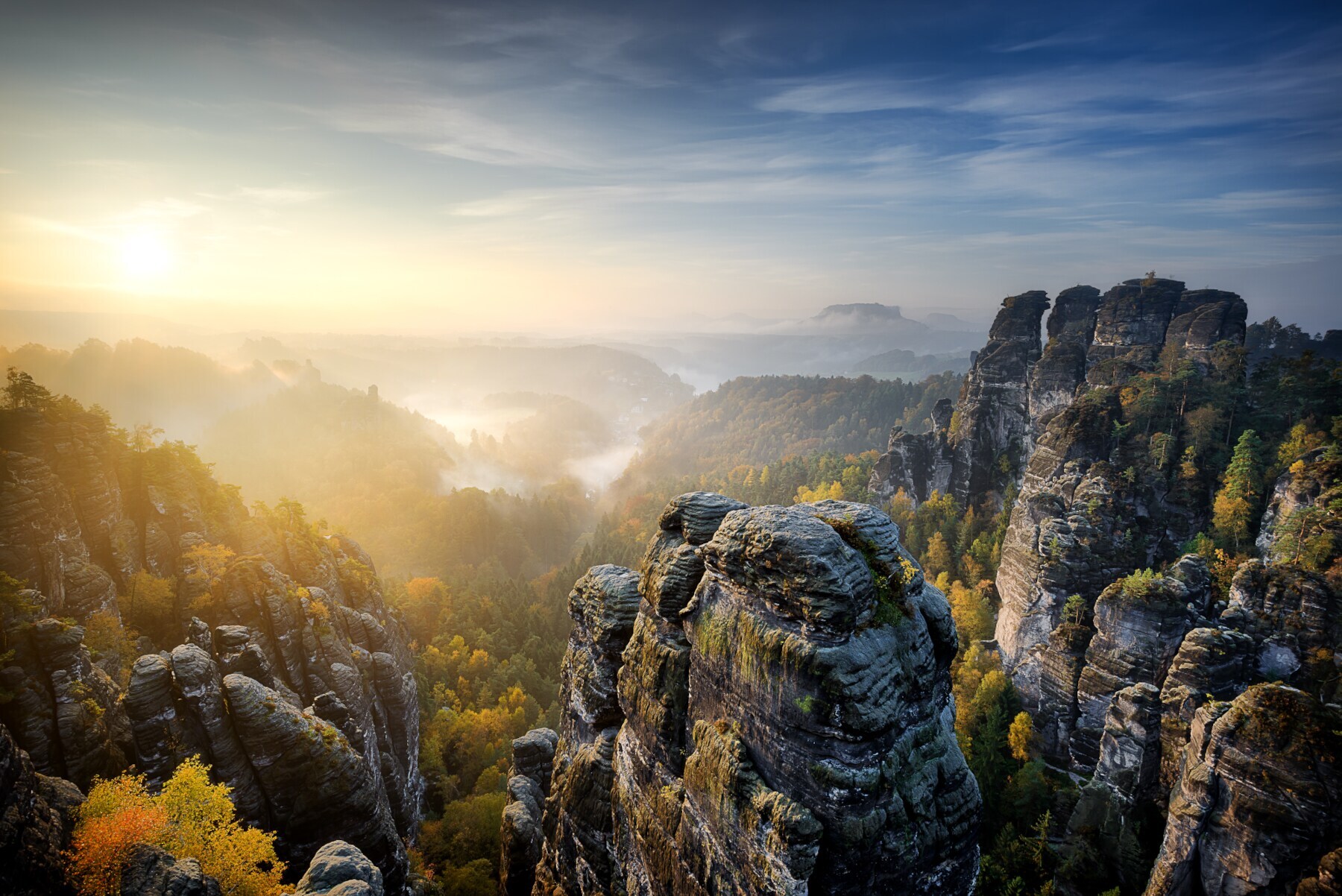 Blick über eine in Nebel gehüllte Sächsische Schweiz bei Sonnenuntergang