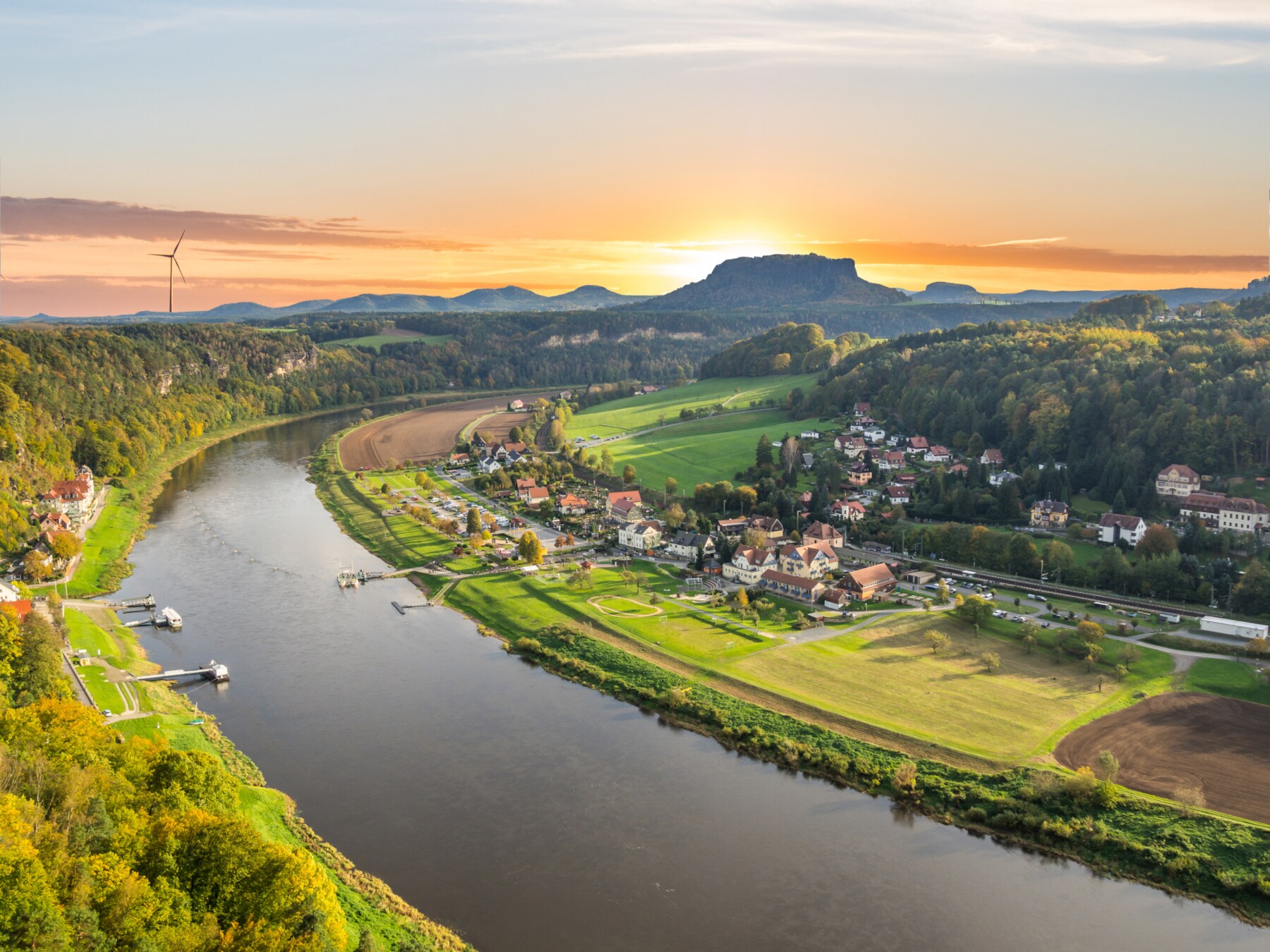 Blick über die Elbe mit dem Königstein im Hintergrund, hinter dem die Sonne untergeht
