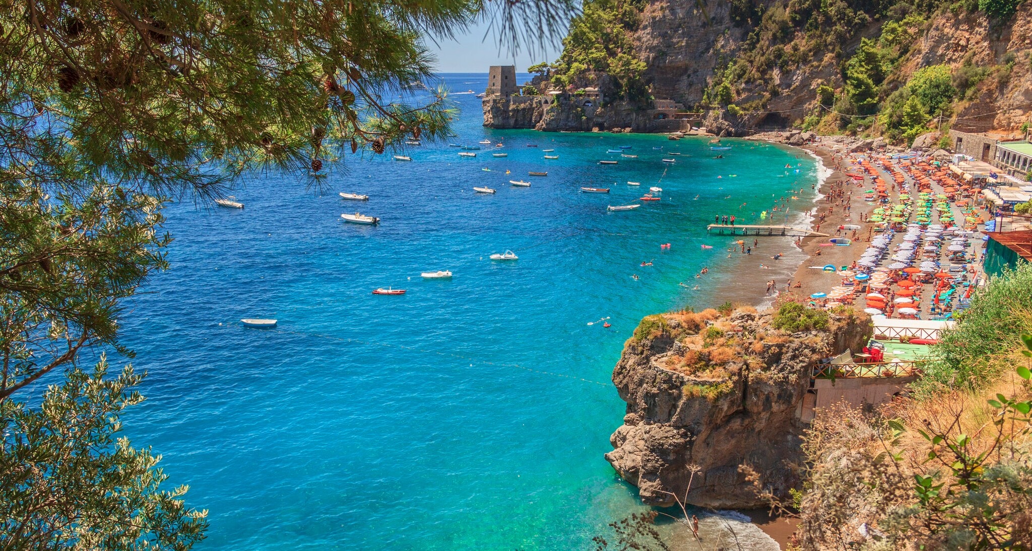 Strand zwischen Felsen von einem erhöhten Blick fotografiert und mit Booten auf dem Wasser. Strand zwischen Felsen von einem erhöhten Blick fotografiert und mit Booten auf dem Wasser.
