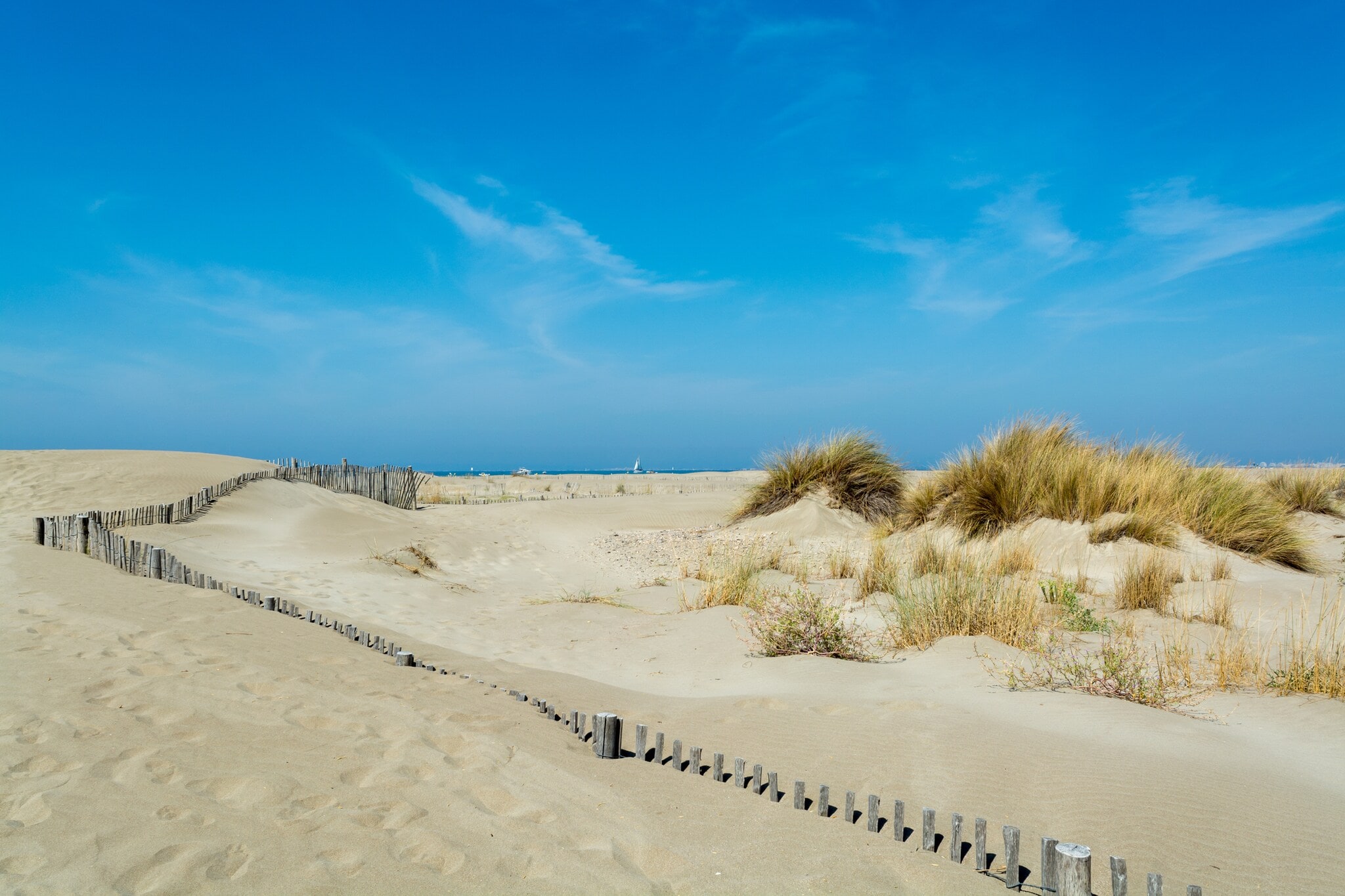 Schöner weißer Sandstrand mit Dünengras und blauem Himmel Schöner weißer Sandstrand mit Dünengras und blauem Himmel