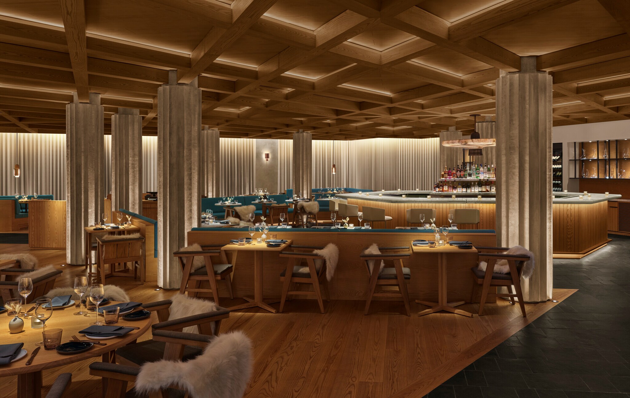 Beleuchtetes Restaurant mit gedeckten Tischen und einer Bar