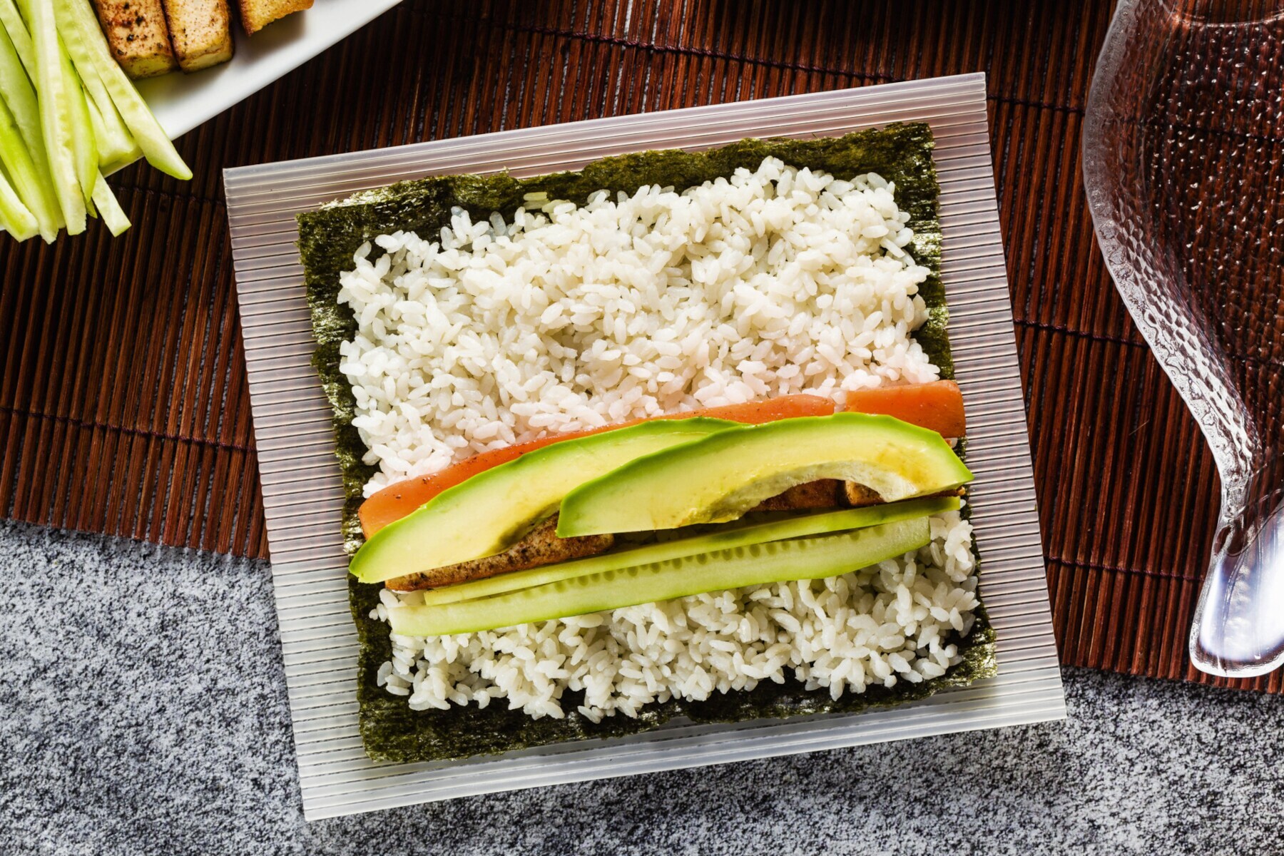 Vegetarisches Sushi in der Zubereitung, bevor es zusammengerollt wird