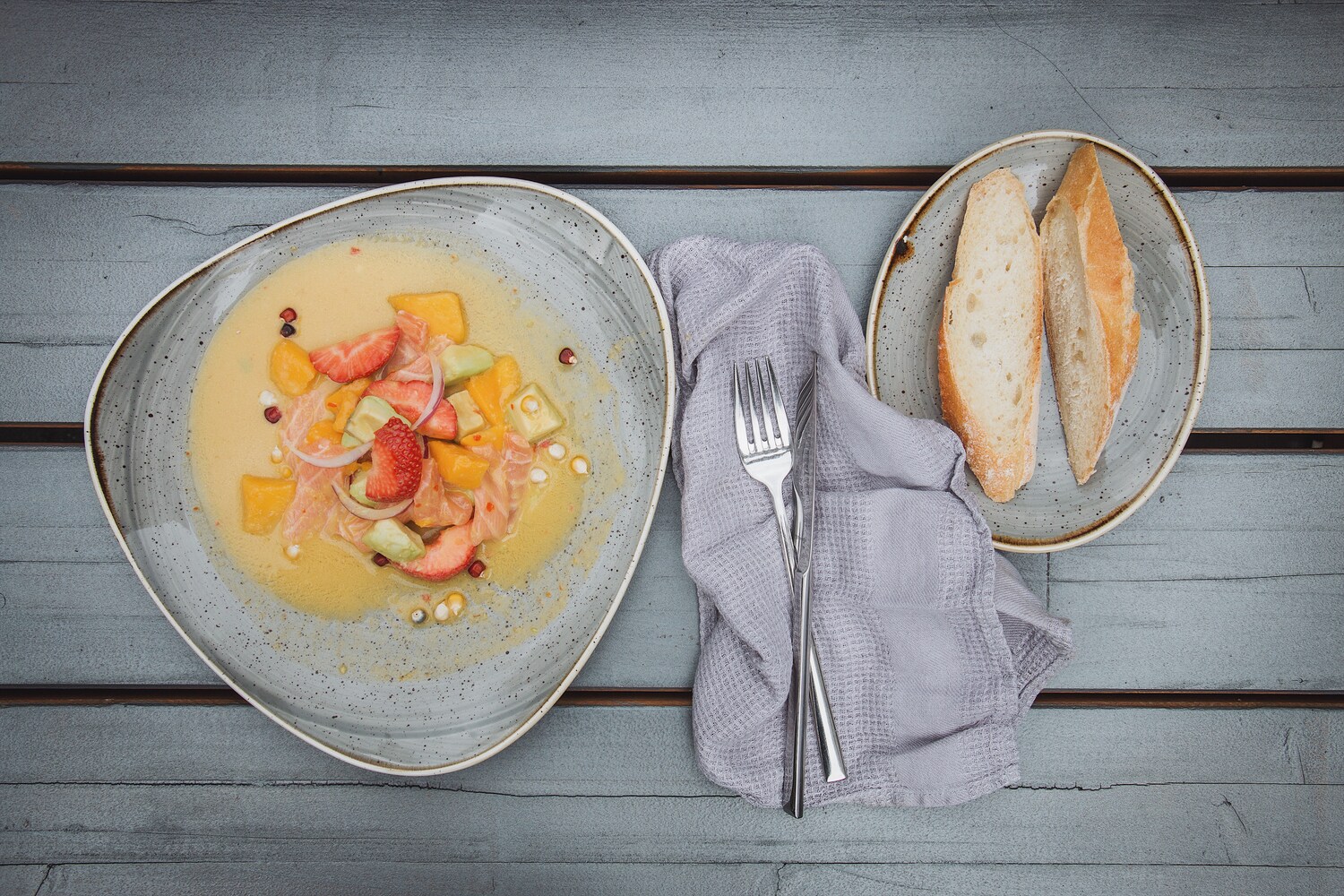 Ein Teller mit einem Gericht neben Besteck und Brot.