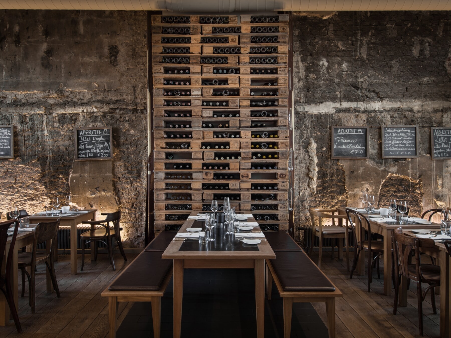 Hohes Weinregal neben rustikaler Steinmauer im Restaurant das ACHT Hohes Weinregal neben rustikaler Steinmauer im Restaurant das ACHT