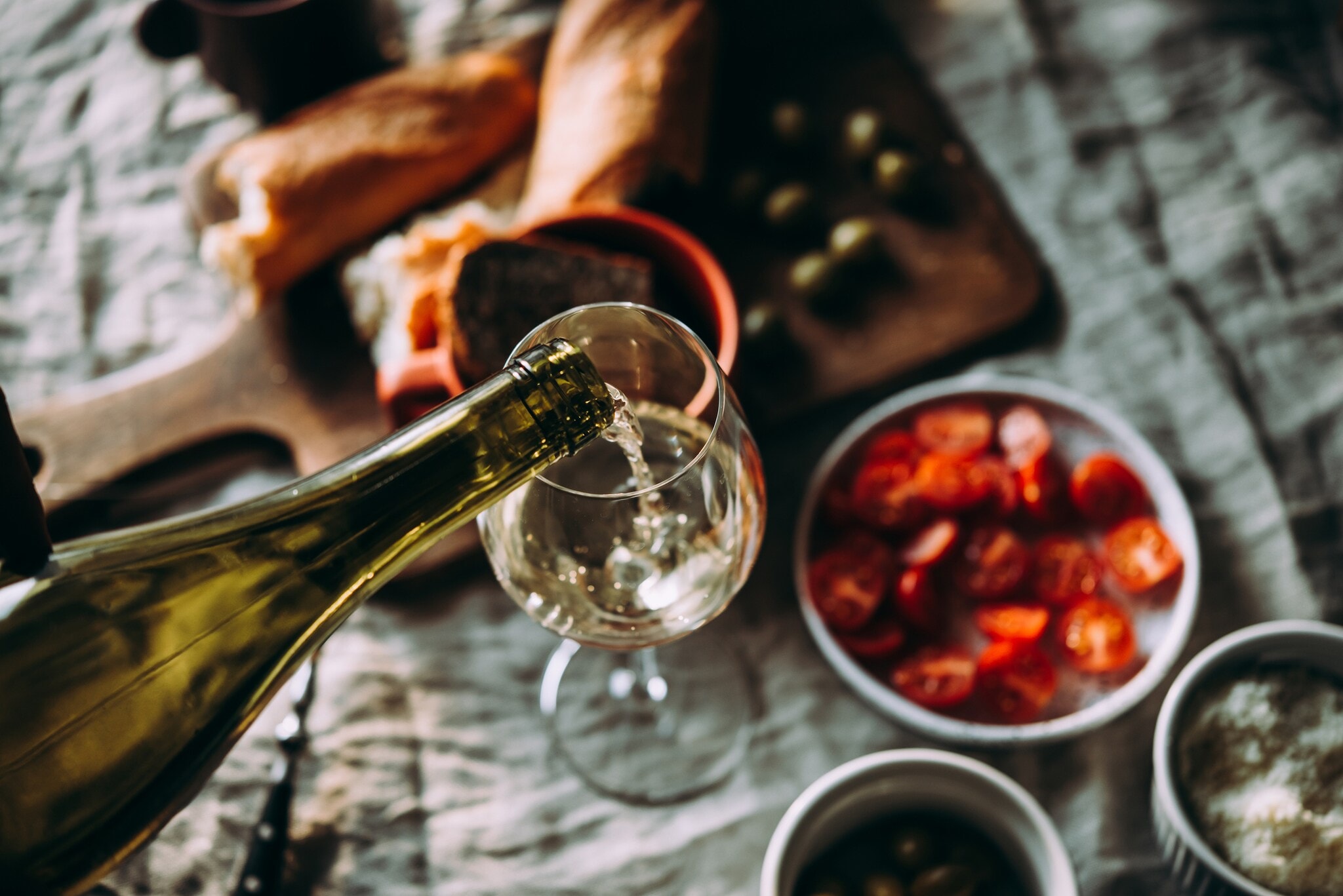 In ein Weinglas wird Weißwein eingeschenkt In ein Weinglas wird Weißwein eingeschenkt