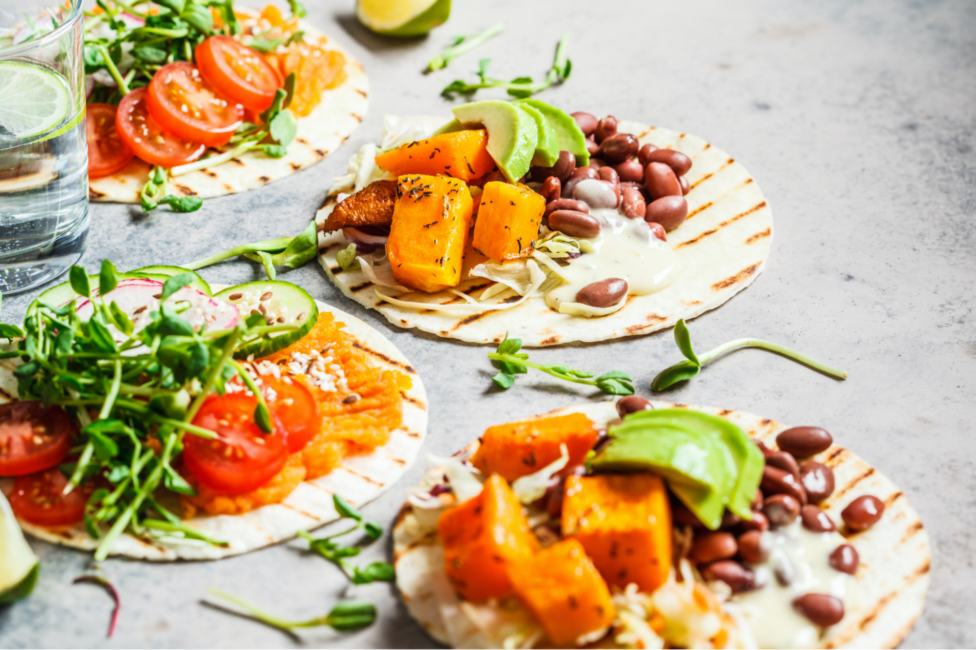 Vegane Tortilla Wraps mit Süßkartoffeln auf einem grauen Untergrund Vegane Tortilla Wraps mit Süßkartoffeln auf einem grauen Untergrund