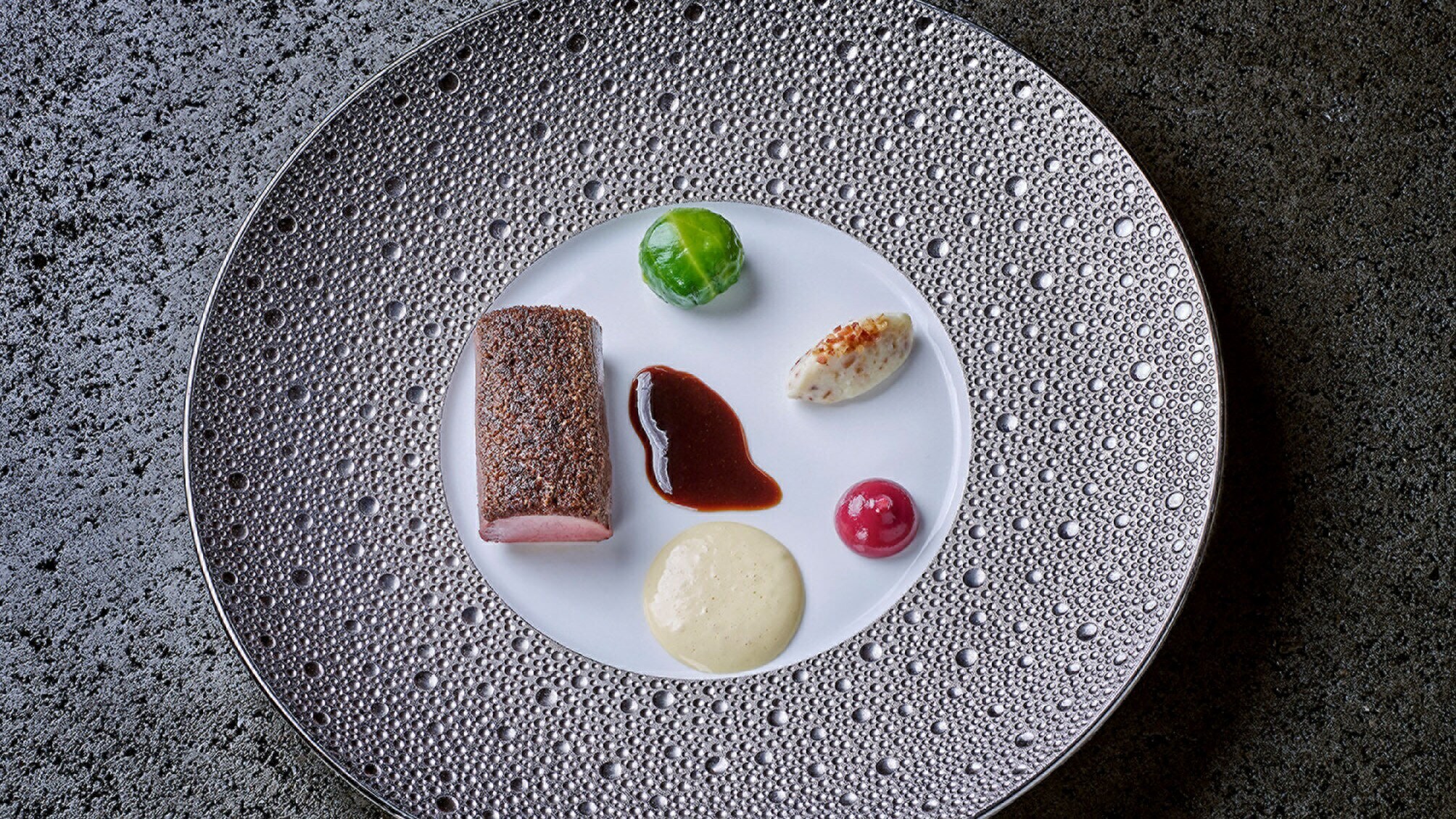 Wenige Speisen und Soßen auf einem Teller arrangiert Wenige Speisen und Soßen auf einem Teller arrangiert