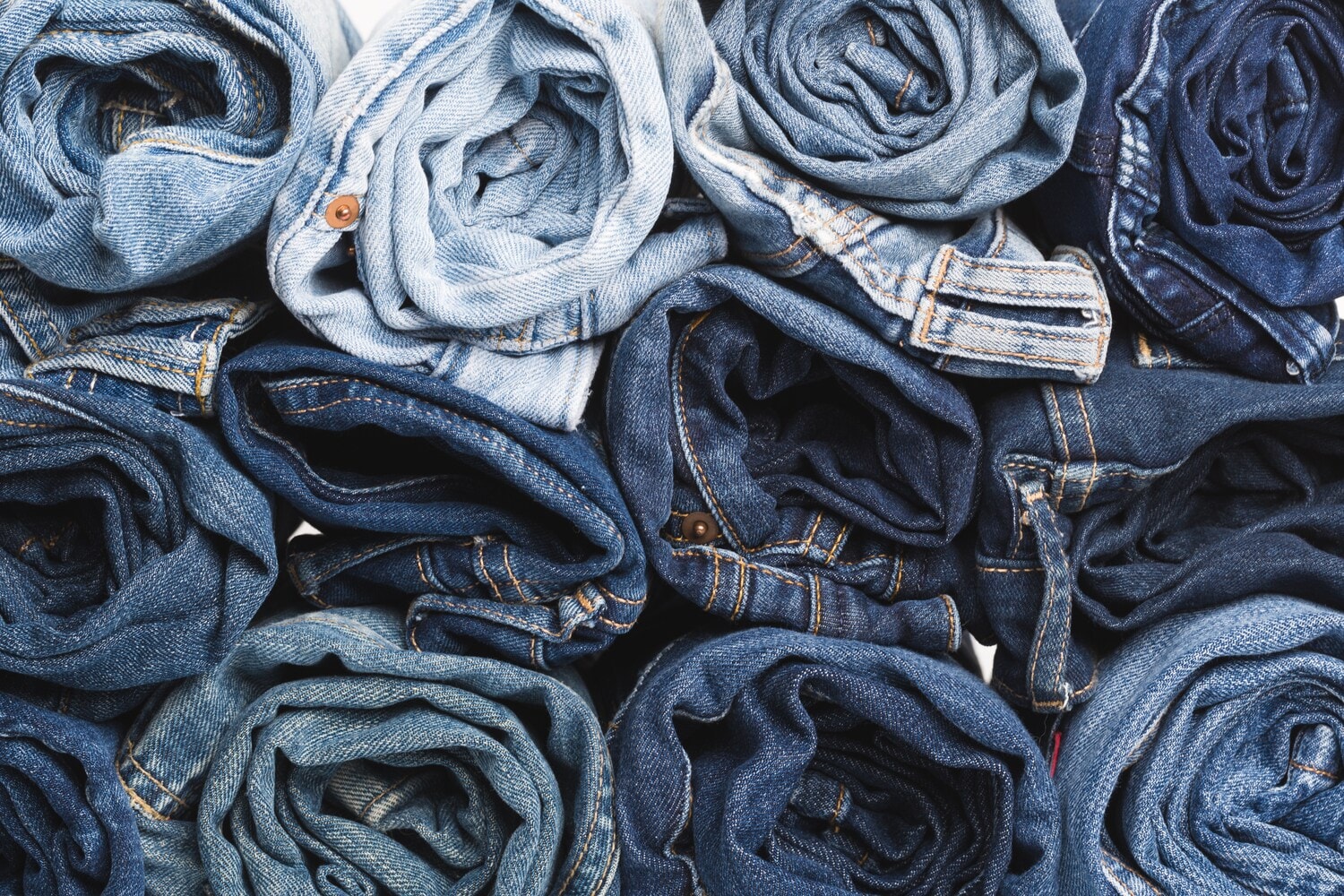 Diverse zusammengerollte Jeans in unterschiedlicher Färbung Diverse zusammengerollte Jeans in unterschiedlicher Färbung