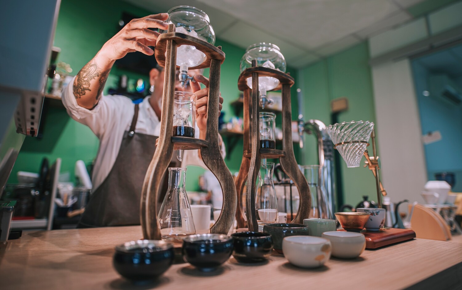 Ein Mann bereitet Cold Brew in speziellen Gefäßen zu.