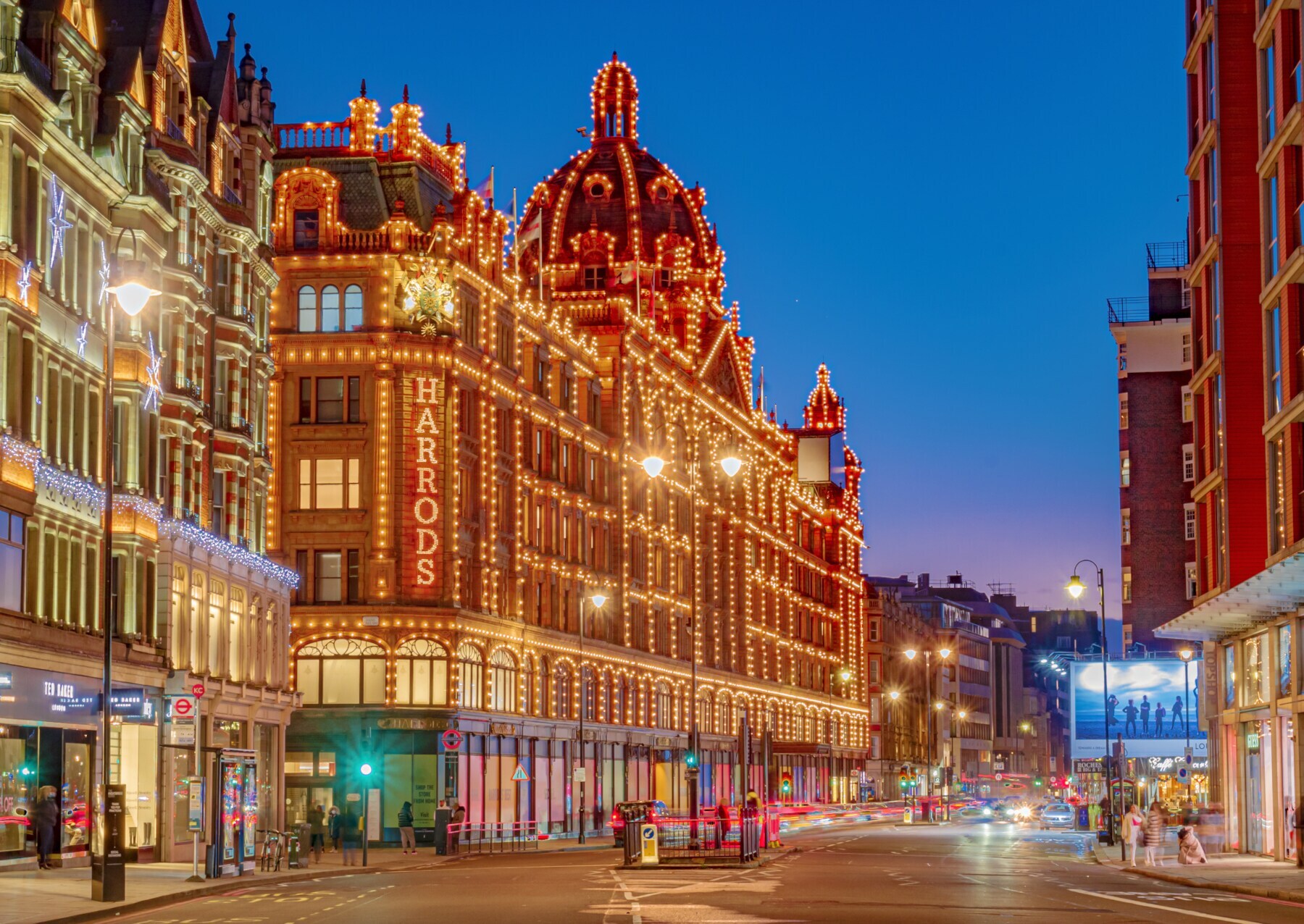 Außenansicht des Kaufhauses Harrods in London mit beleuchteter Fassade bei Nacht