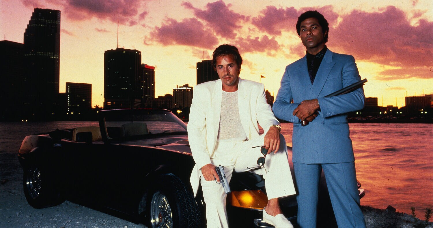 Zwei Männer in Anzügen vor einem schwarzen Cabriolet in der Dämmerung Zwei Männer in Anzügen vor einem schwarzen Cabriolet in der Dämmerung